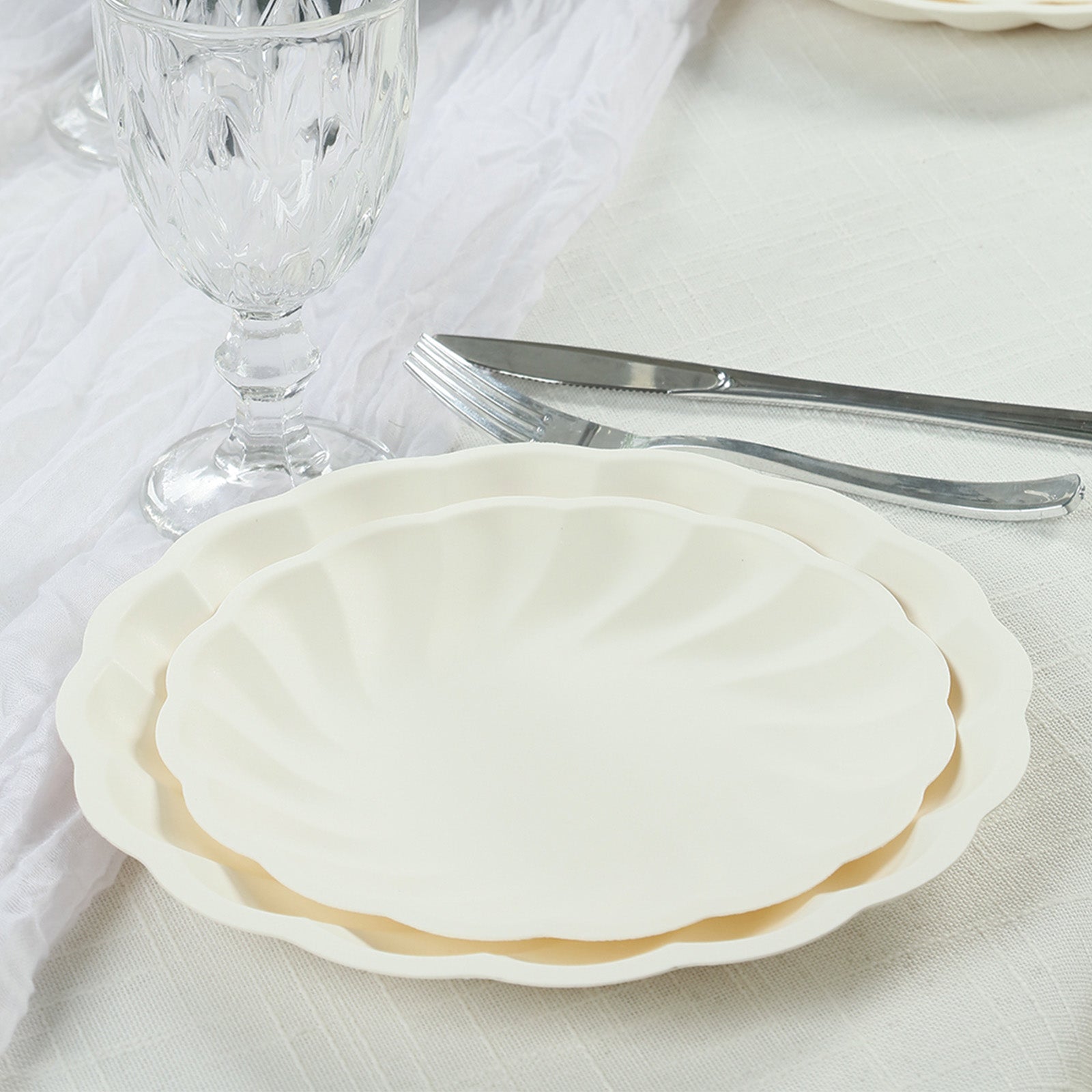 Cream biodegradable salad plates with elegant swirl scalloped design.