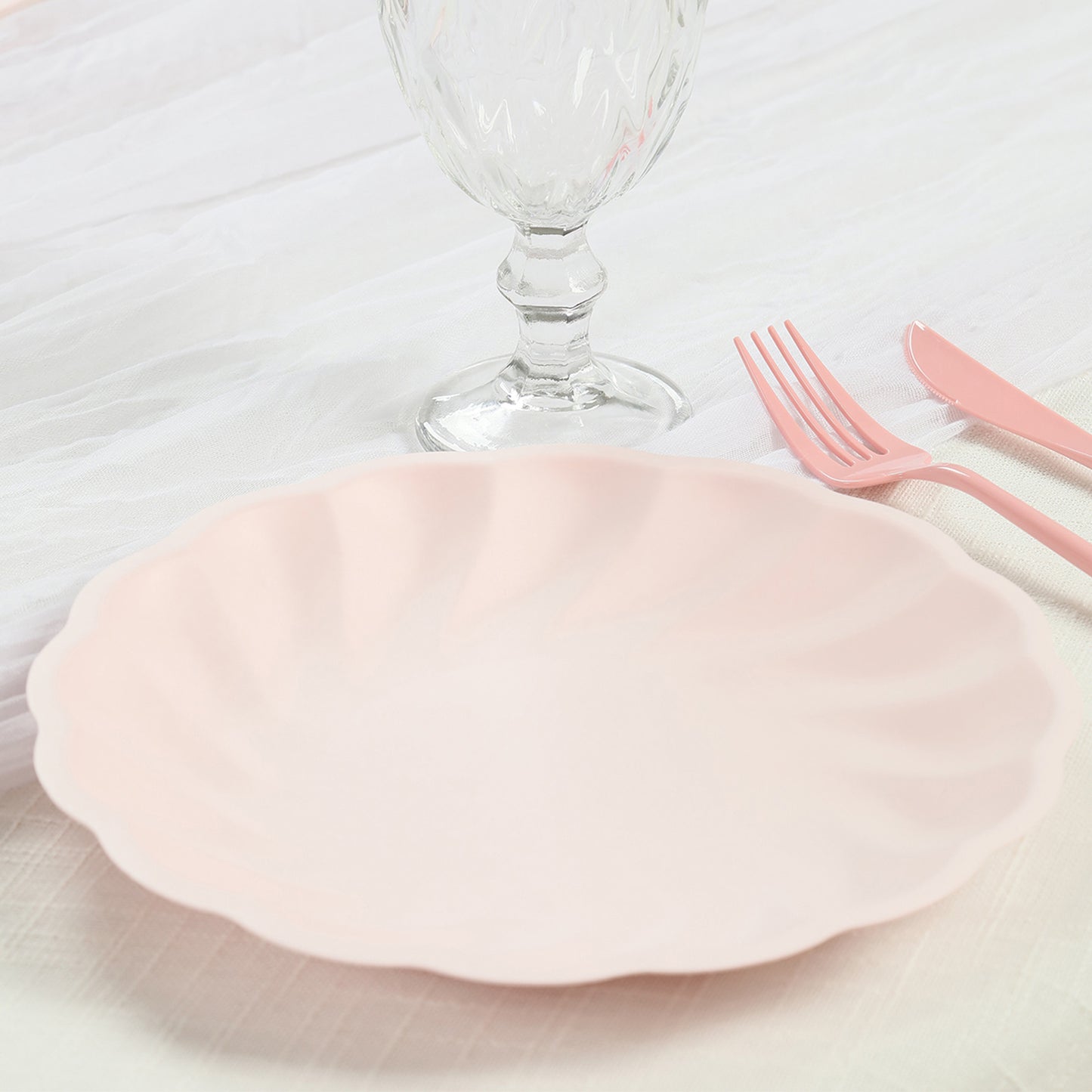 Blush biodegradable dinner plate with swirl scalloped design.