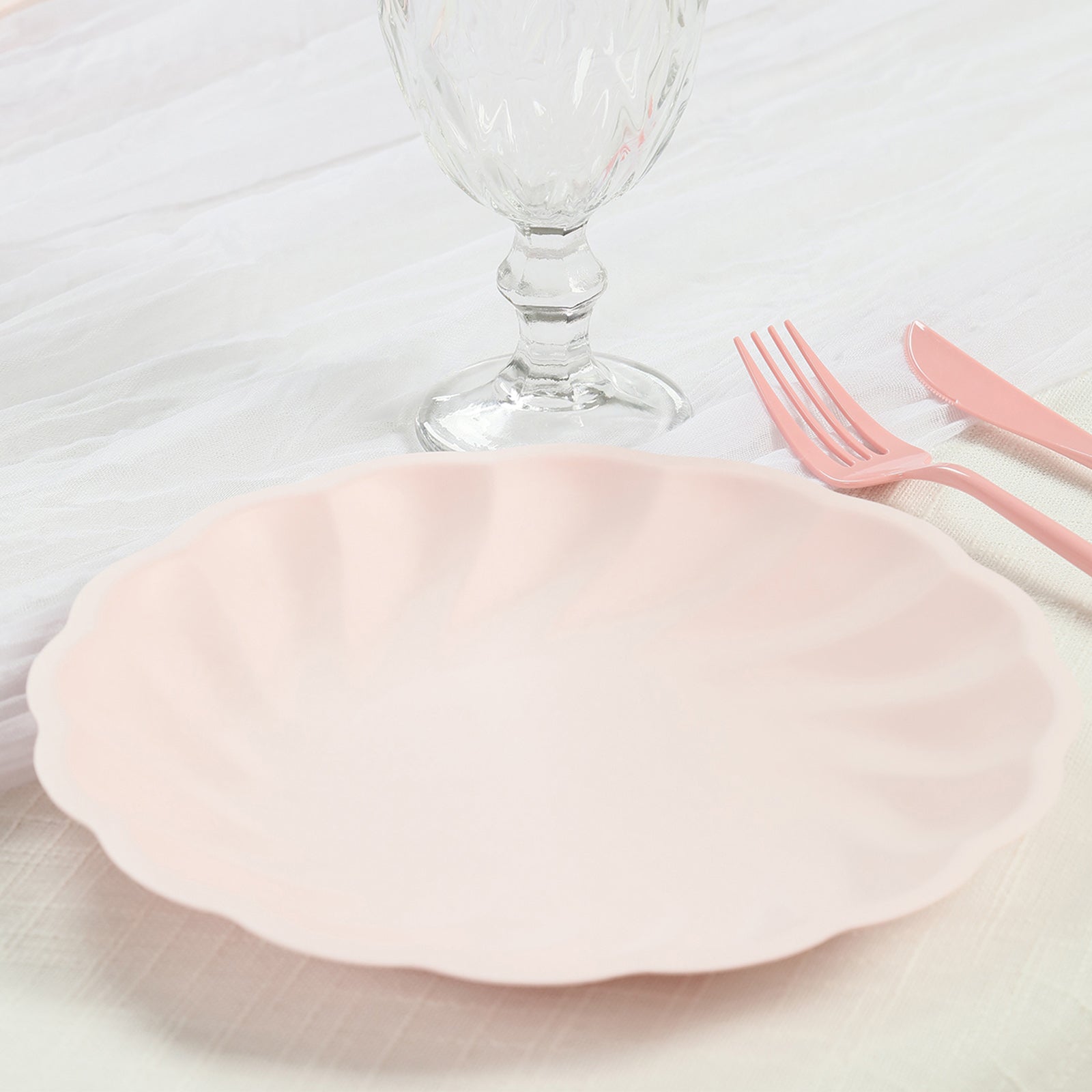Blush biodegradable dinner plate with swirl scalloped design.