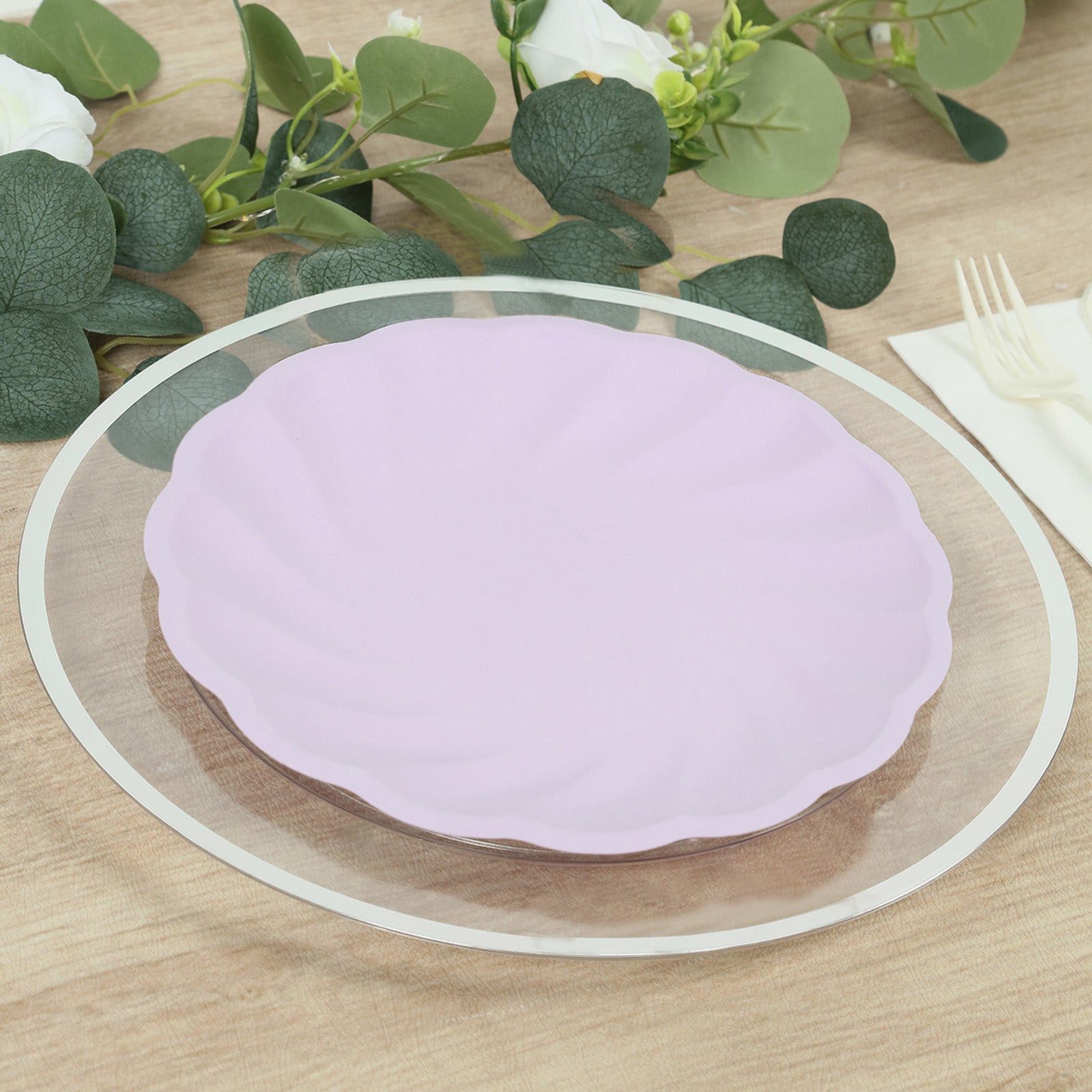 Lavender lilac biodegradable dinner plate on a wooden table with greenery.