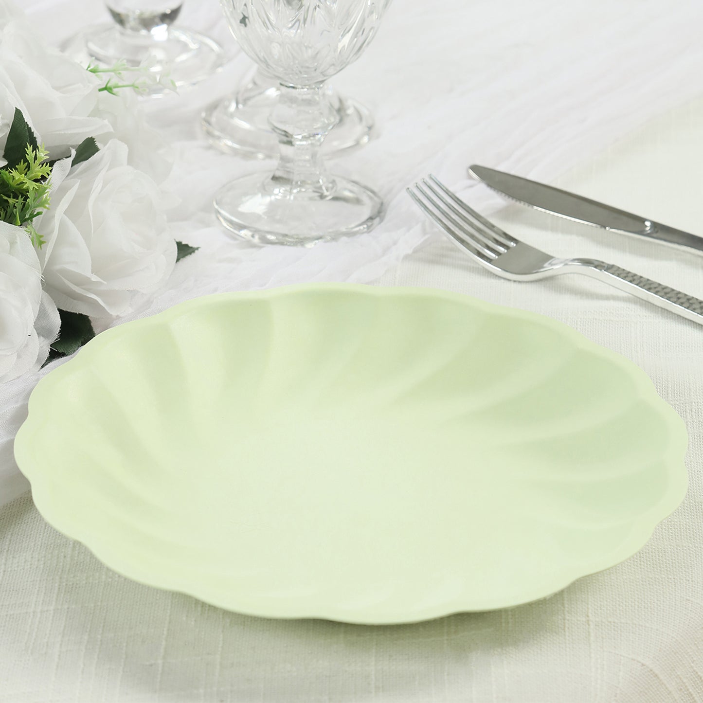 Sage green biodegradable dinner plate with a swirl scalloped design.