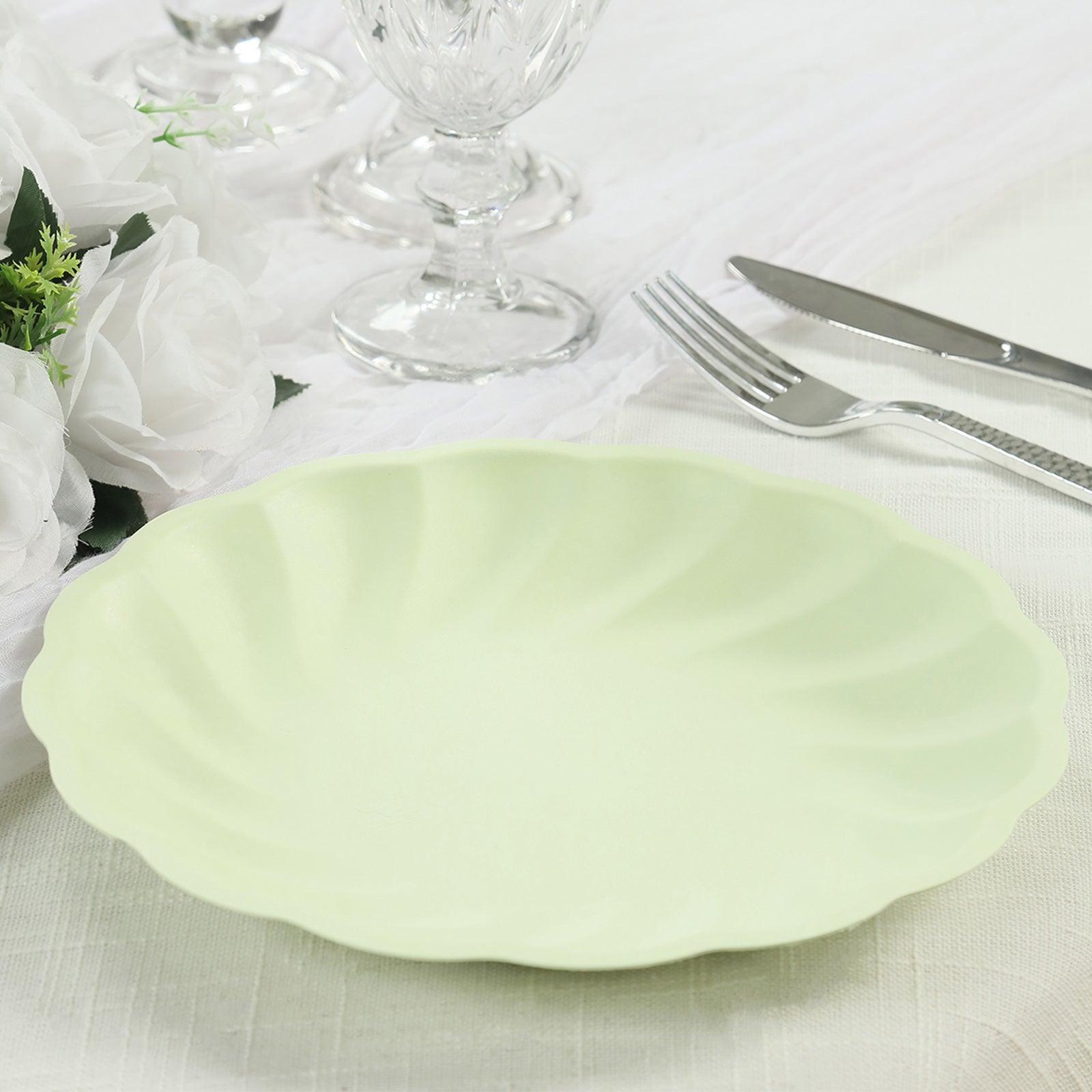 Sage green biodegradable dinner plate with a swirl scalloped design.
