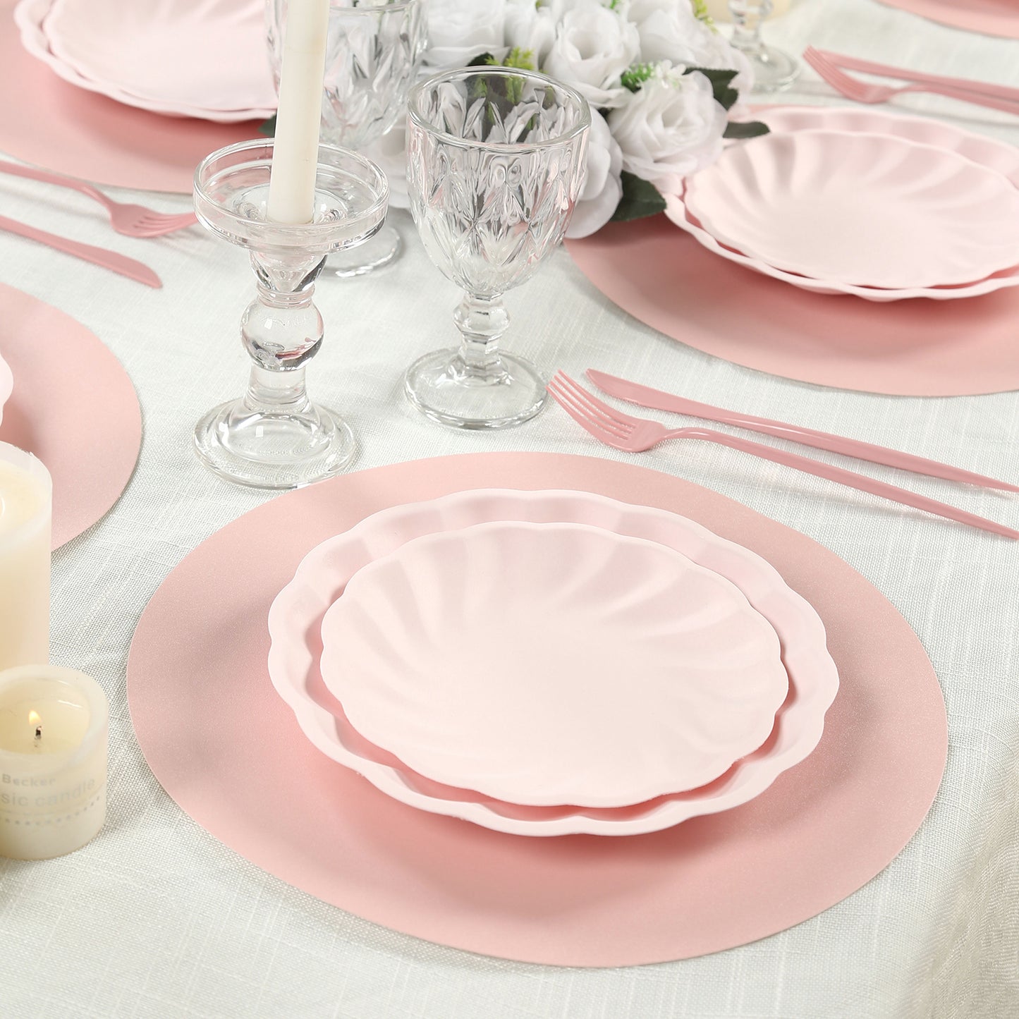 Pink disposable paper placemats on a dining table setting.