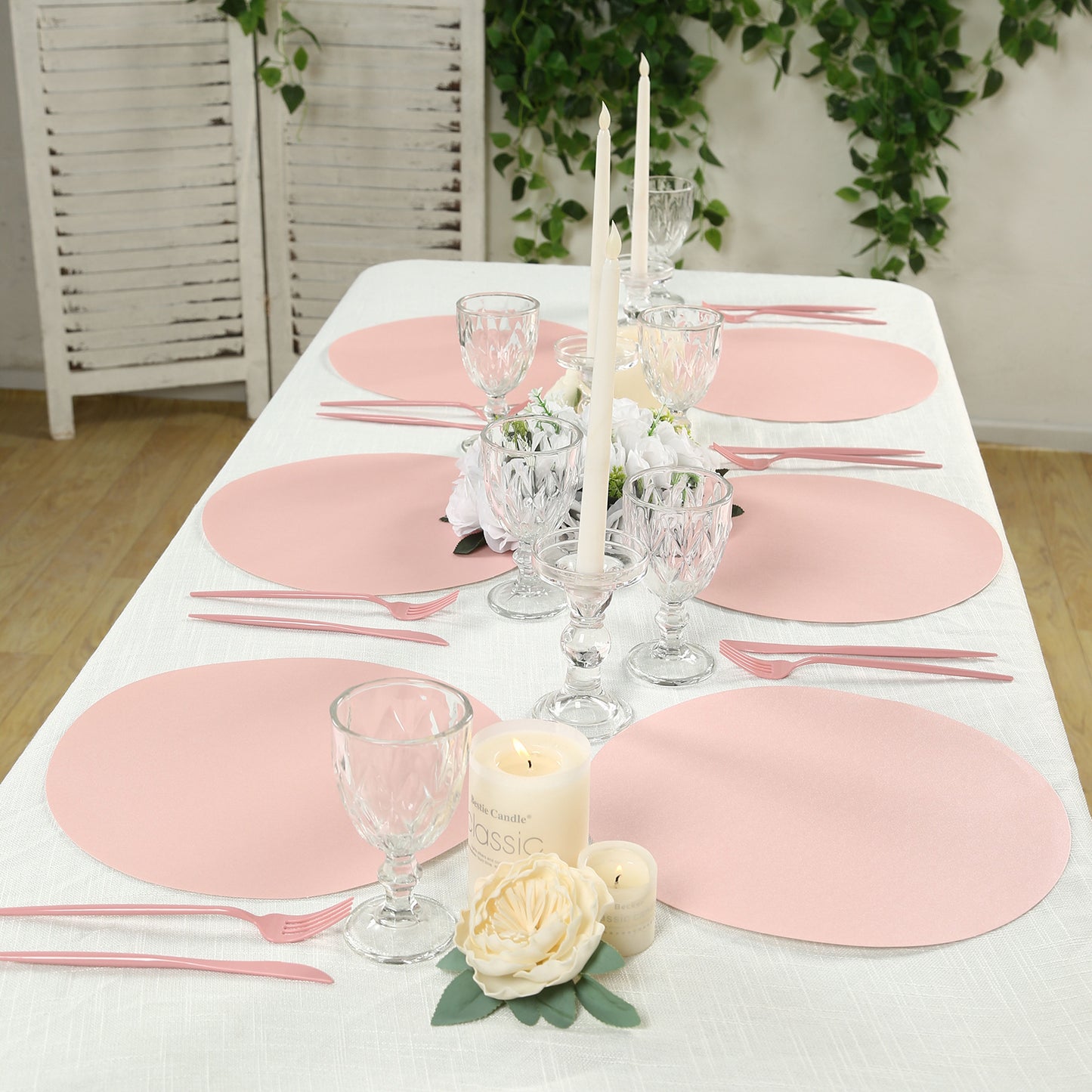 Pink disposable paper placemats set on a dining table.