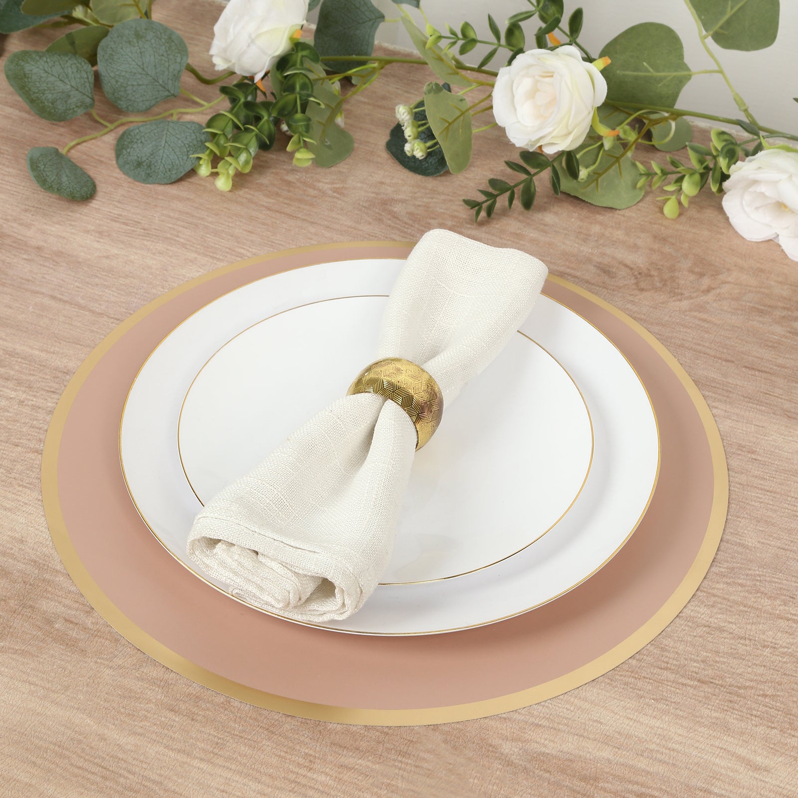 Dusty rose round disposable table placemats with gold rim for events.