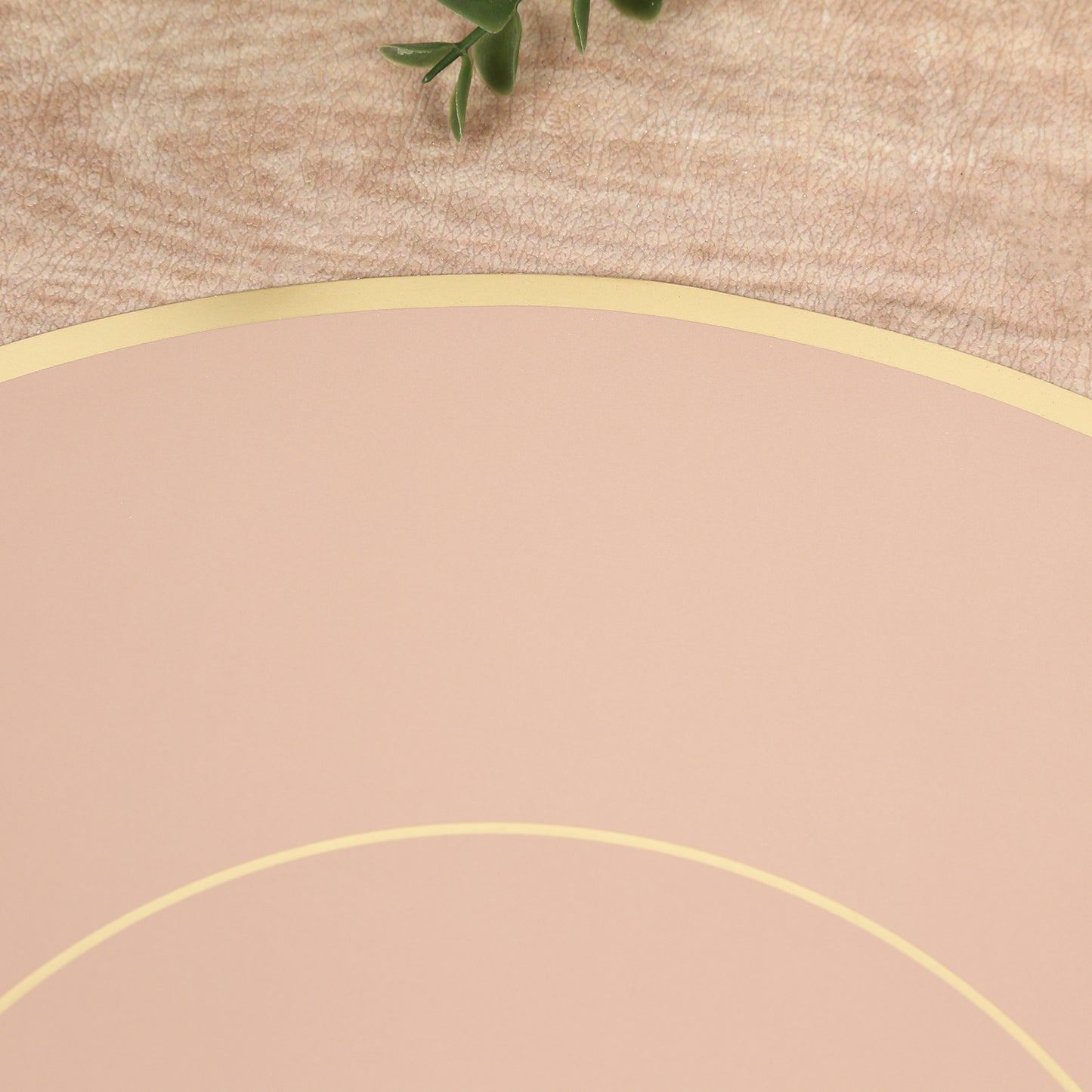 Dusty rose round disposable table placemat with gold rim.