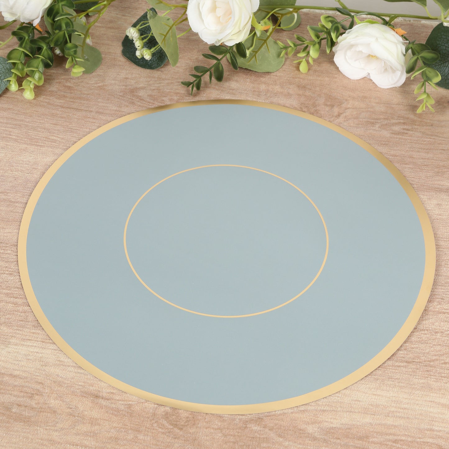 Dusty blue round disposable placemat with gold rim.