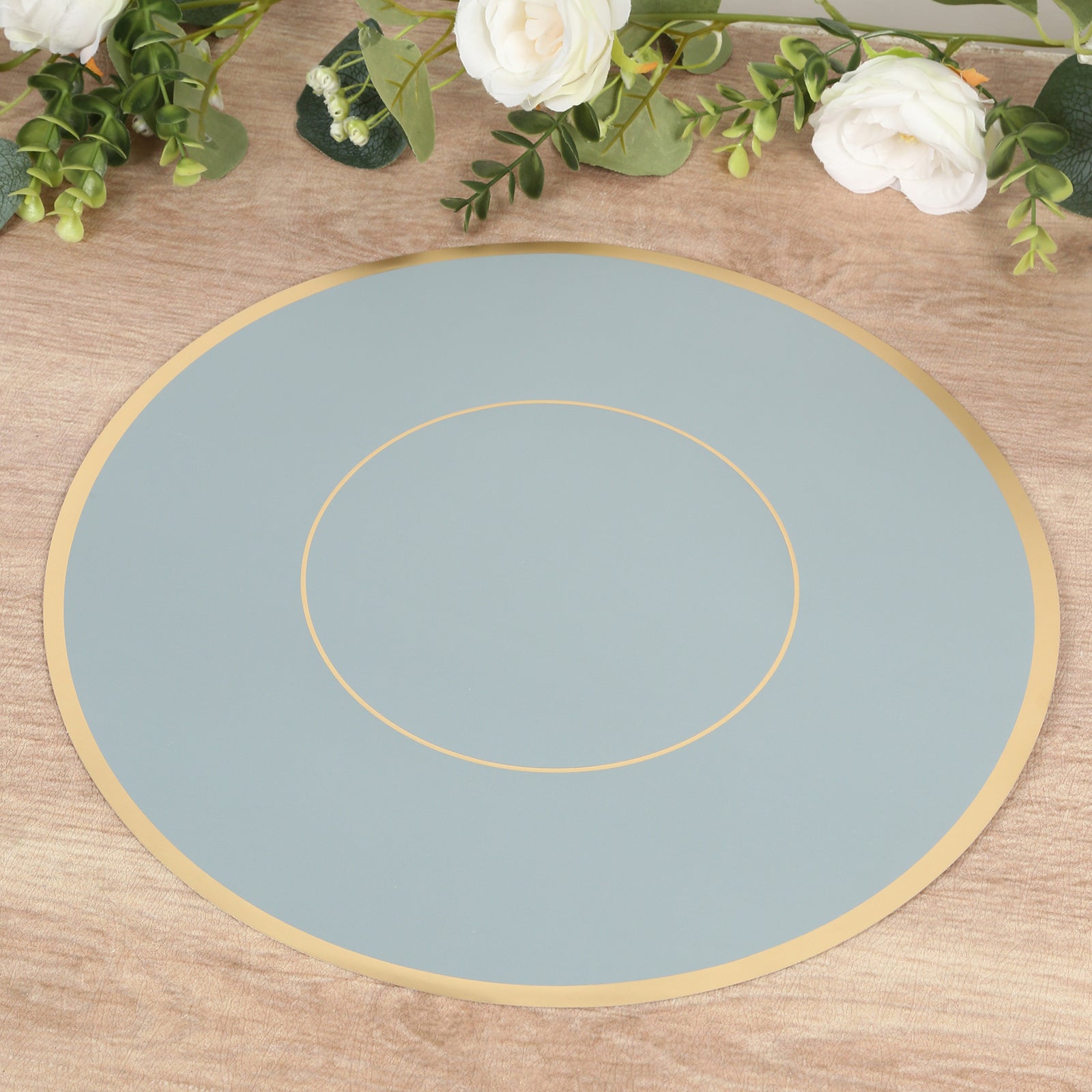 Dusty blue round disposable placemat with gold rim.