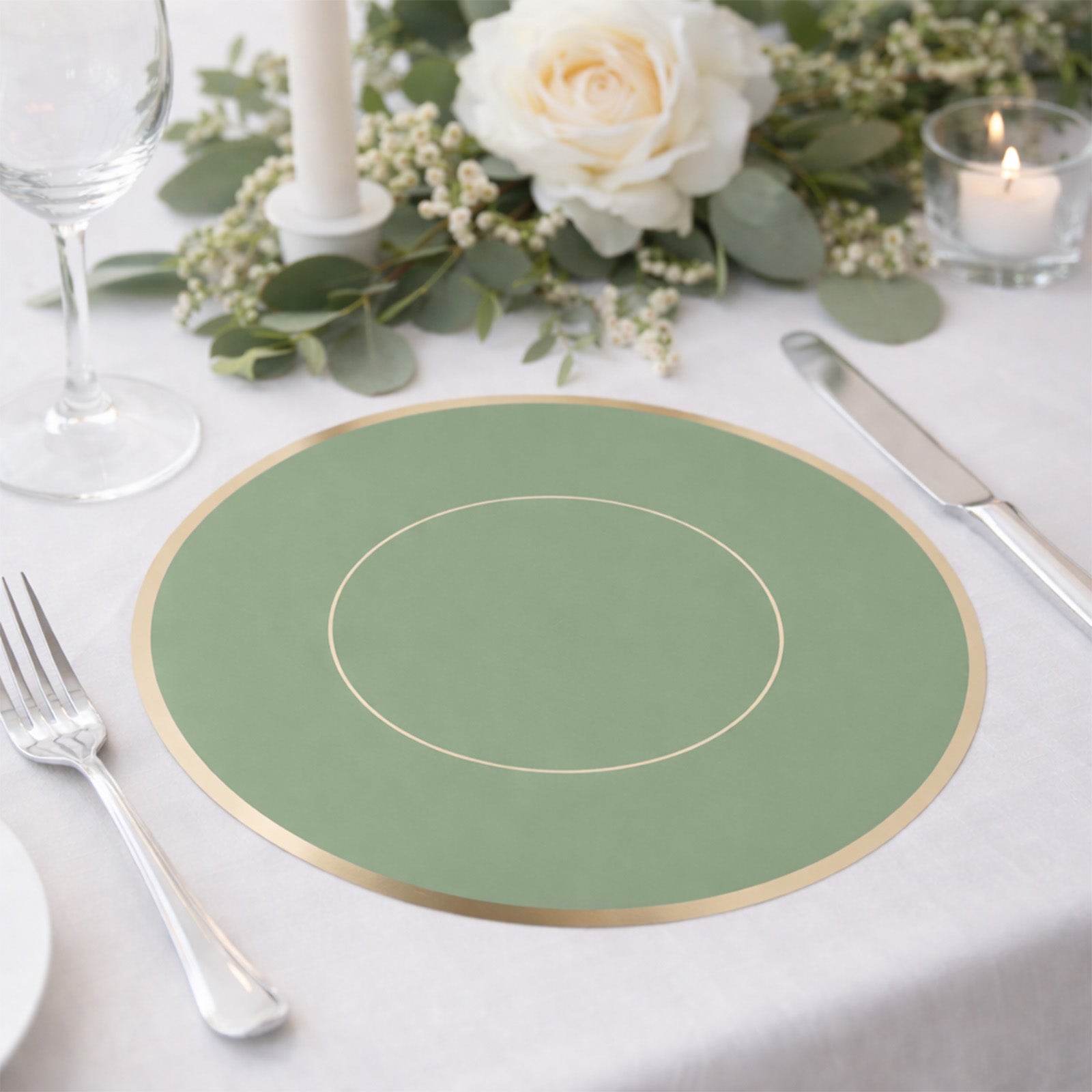 Sage green round disposable placemat with gold rim on a dining table setting.