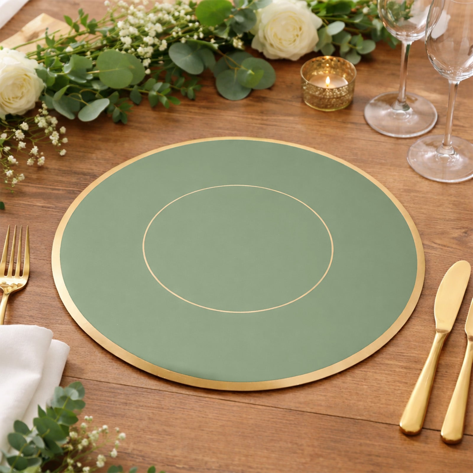 Sage green round disposable placemat with gold rim on a wooden table setting.