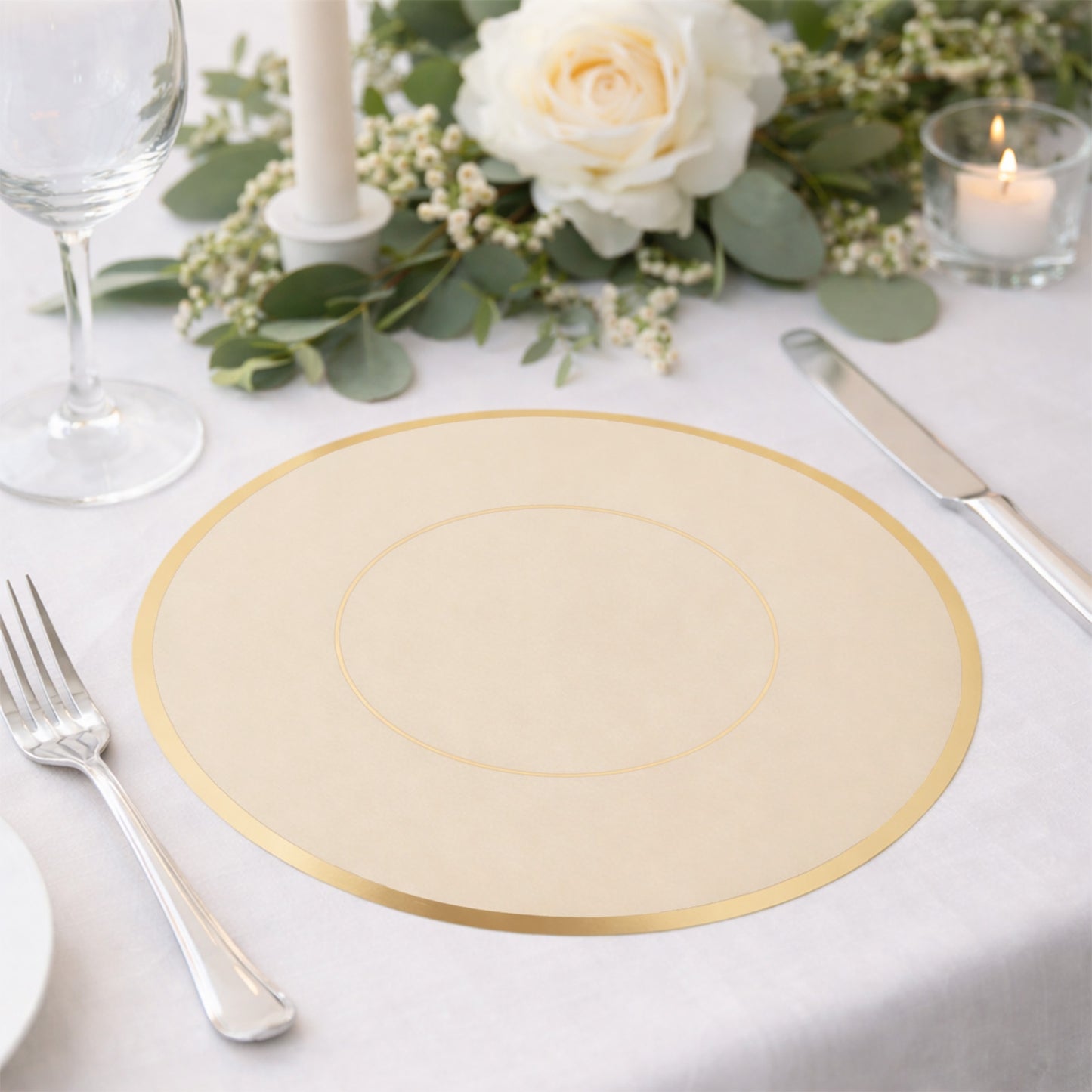 Taupe round disposable placemat with gold rim on a dining table.