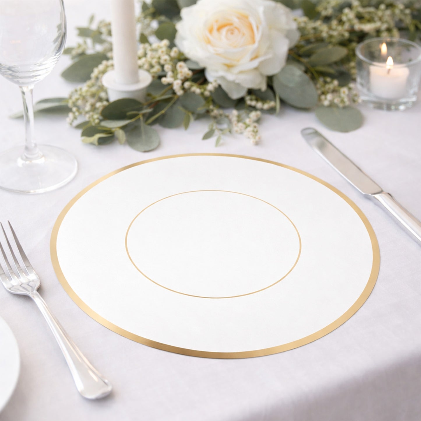 White round disposable table placemat with gold rim on a dining table setting.