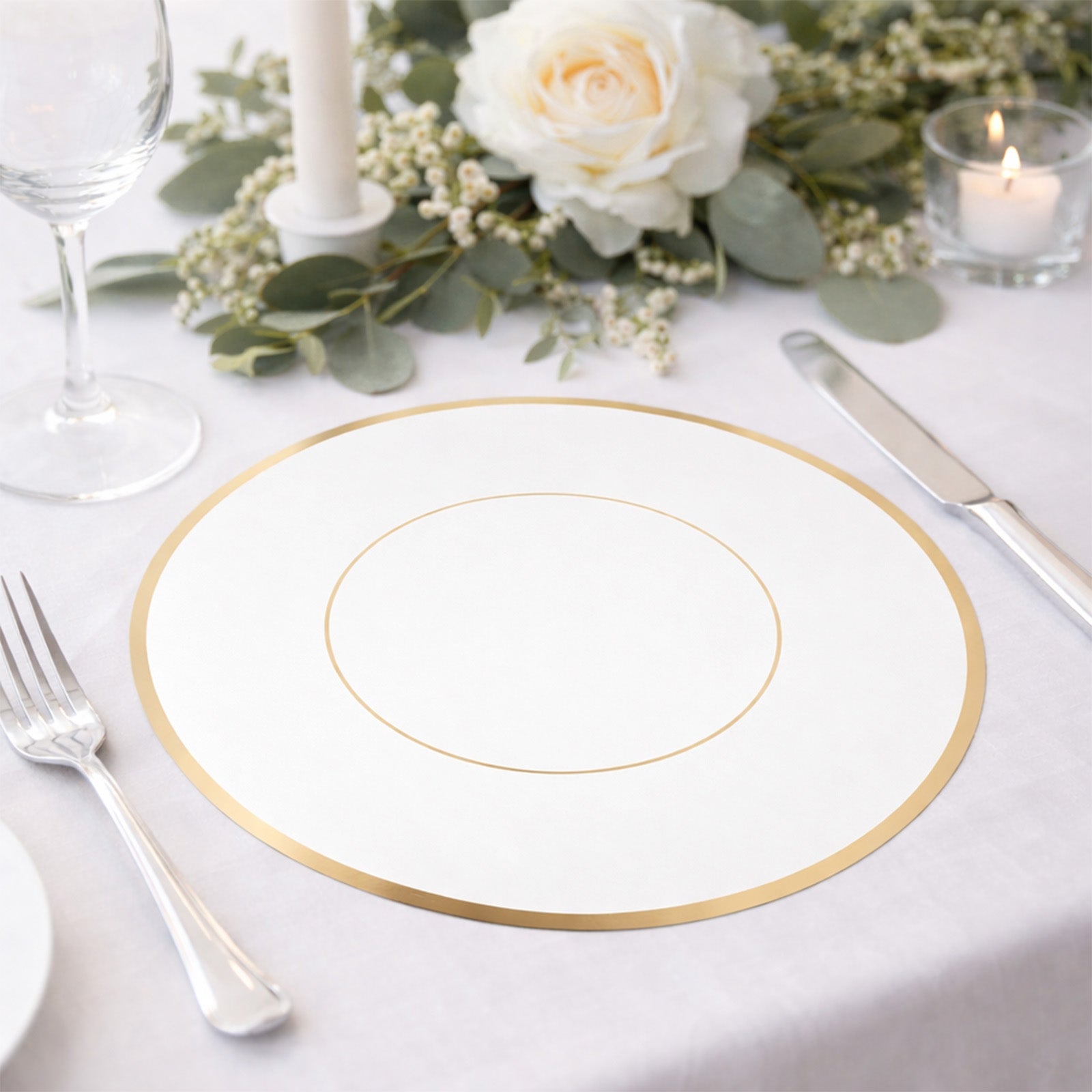 White round disposable table placemat with gold rim on a dining table setting.