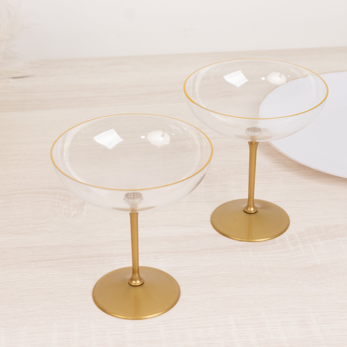 Clear glass dessert cups with gold accents on a wooden table.