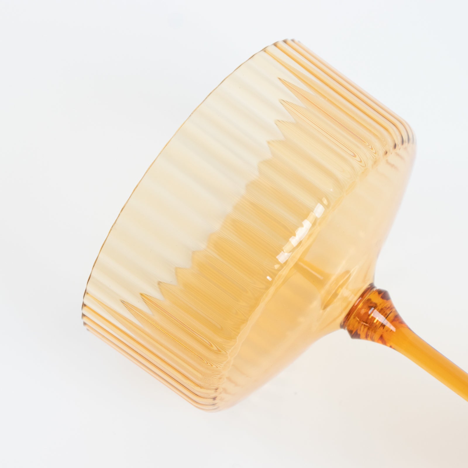 Amber gold disposable cocktail glass with ribbed design.