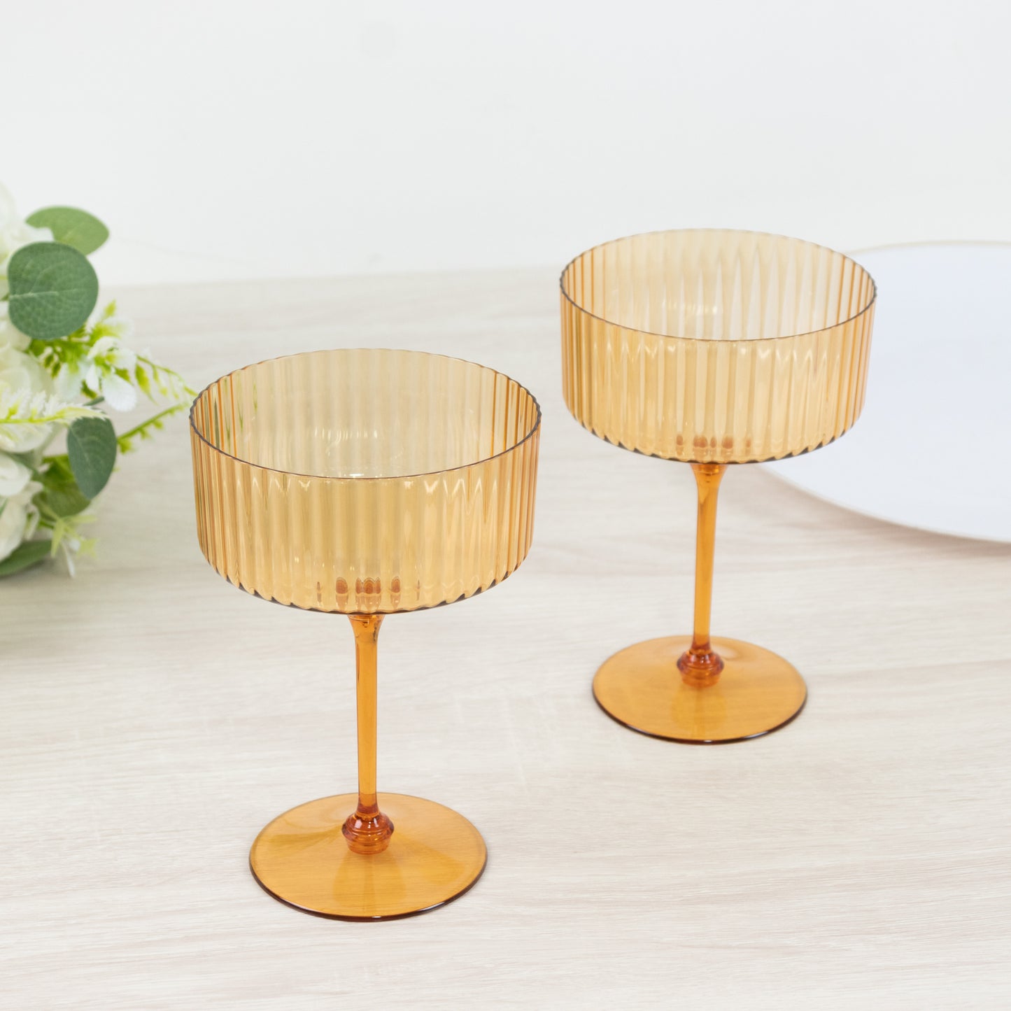 Amber gold disposable cocktail glasses on a table.