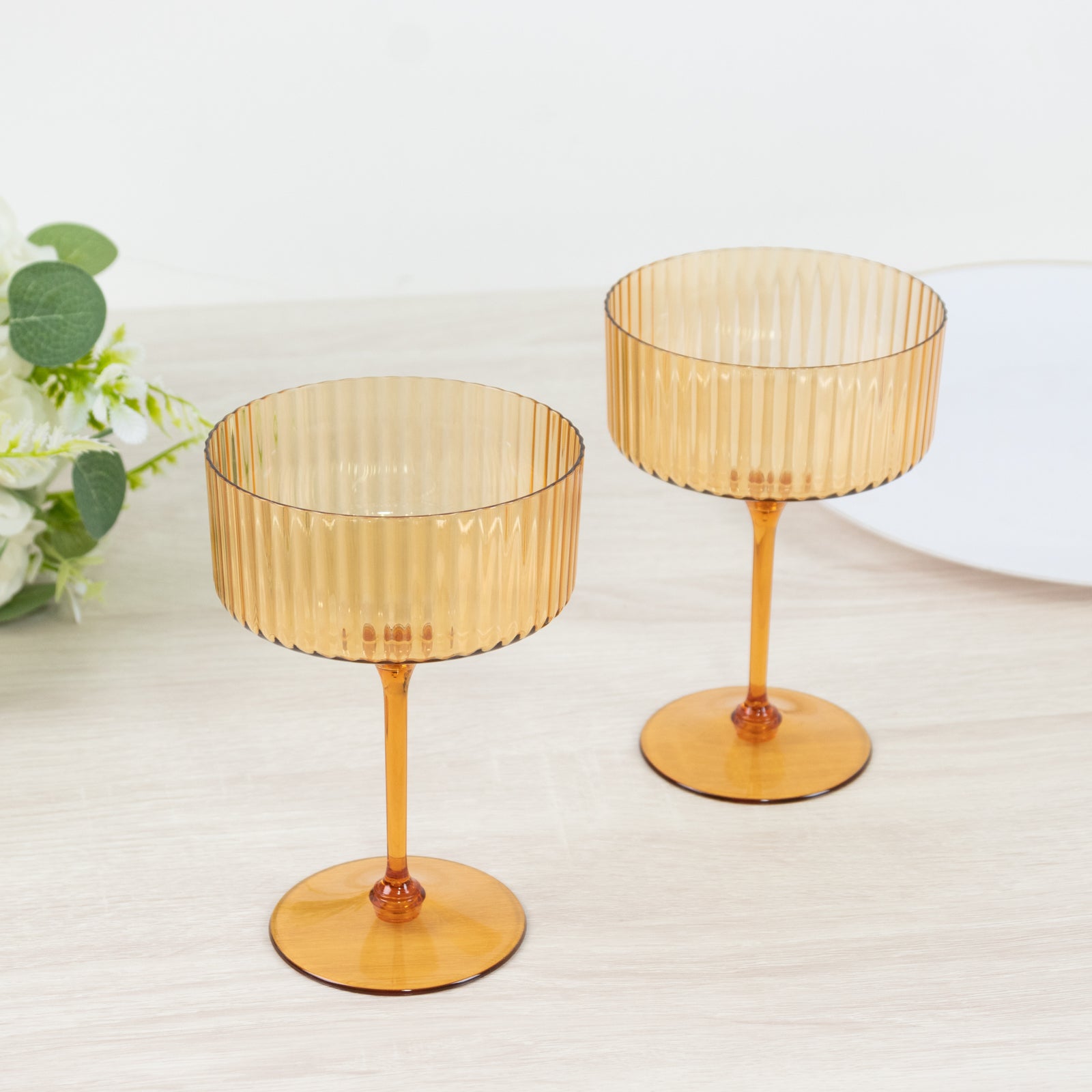 Amber gold disposable cocktail glasses on a table.