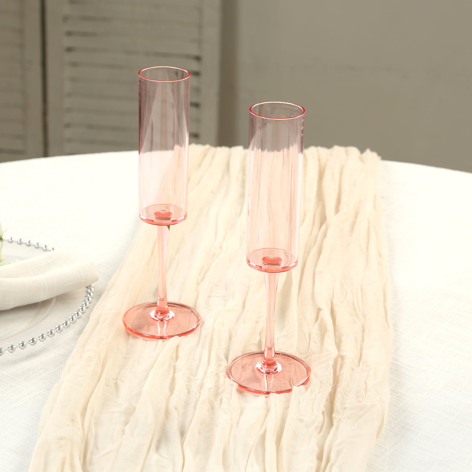 Transparent blush champagne flute glasses, 6oz, tall with long stems.