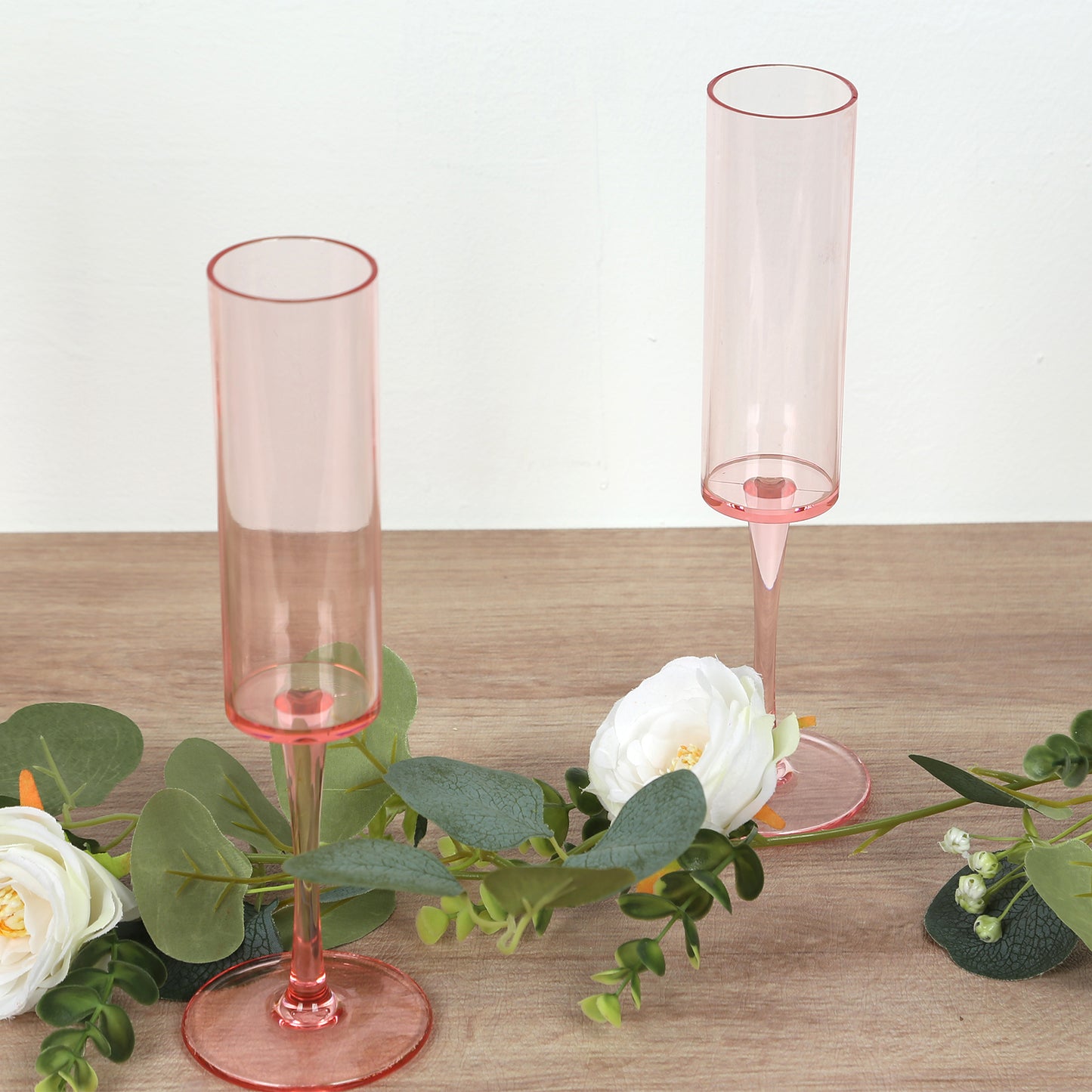 Transparent blush champagne flute glasses with long stems.