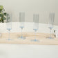 Transparent dusty blue reusable plastic champagne flutes with long stems.