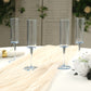 Transparent dusty blue reusable plastic champagne flutes on a table.