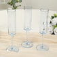 Transparent dusty blue champagne flutes with long stems on a light table setting.