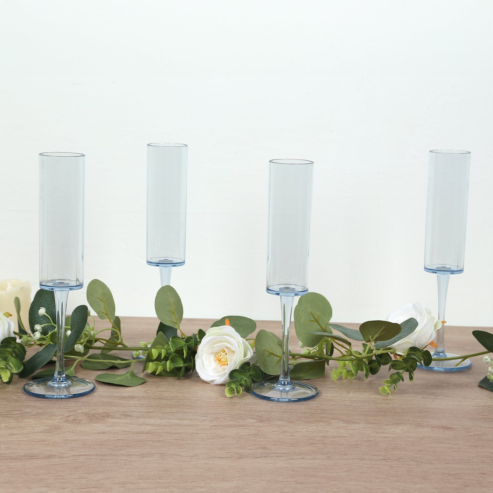Dusty blue reusable plastic champagne flute glasses with long stems.