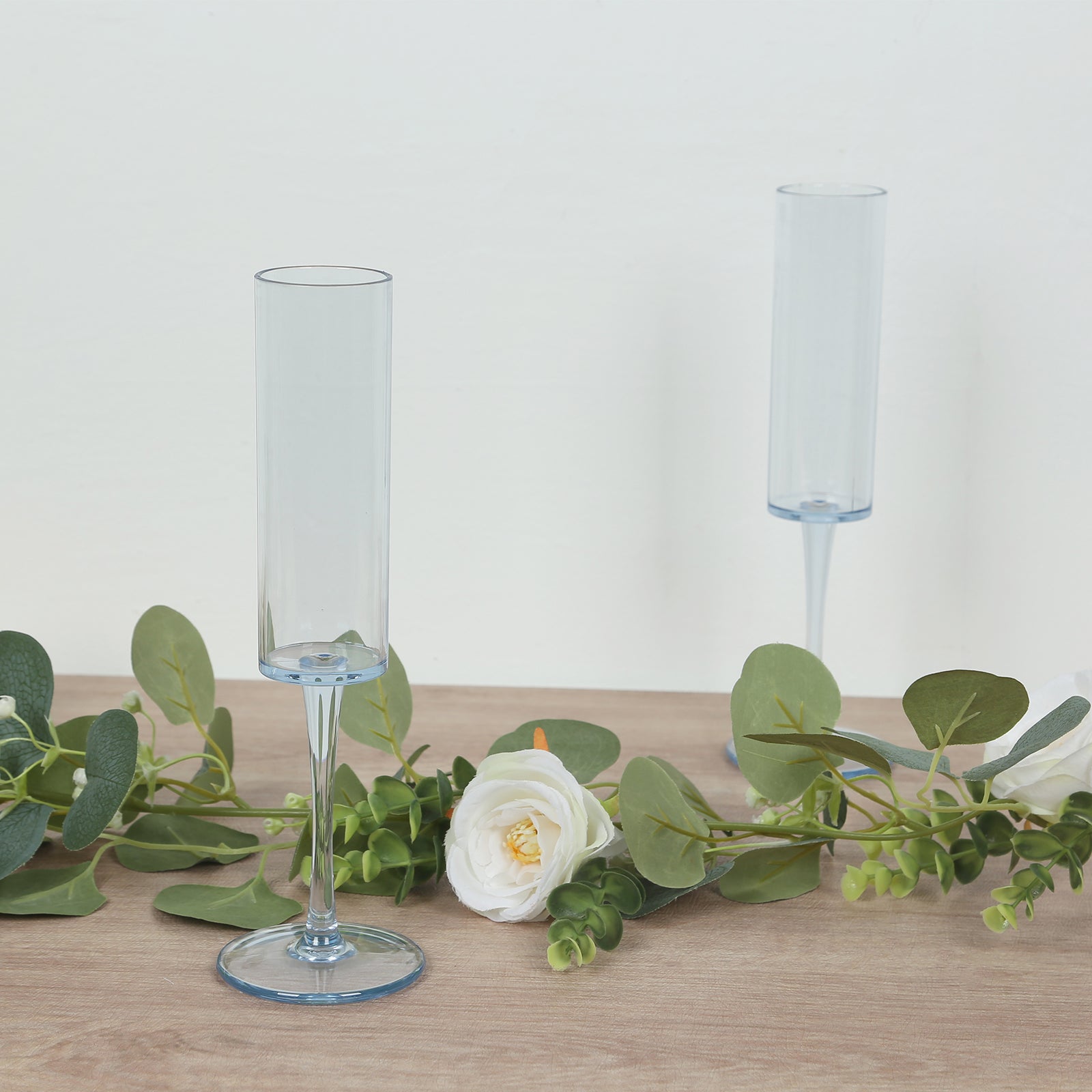 Transparent dusty blue champagne flute glasses with long stems.