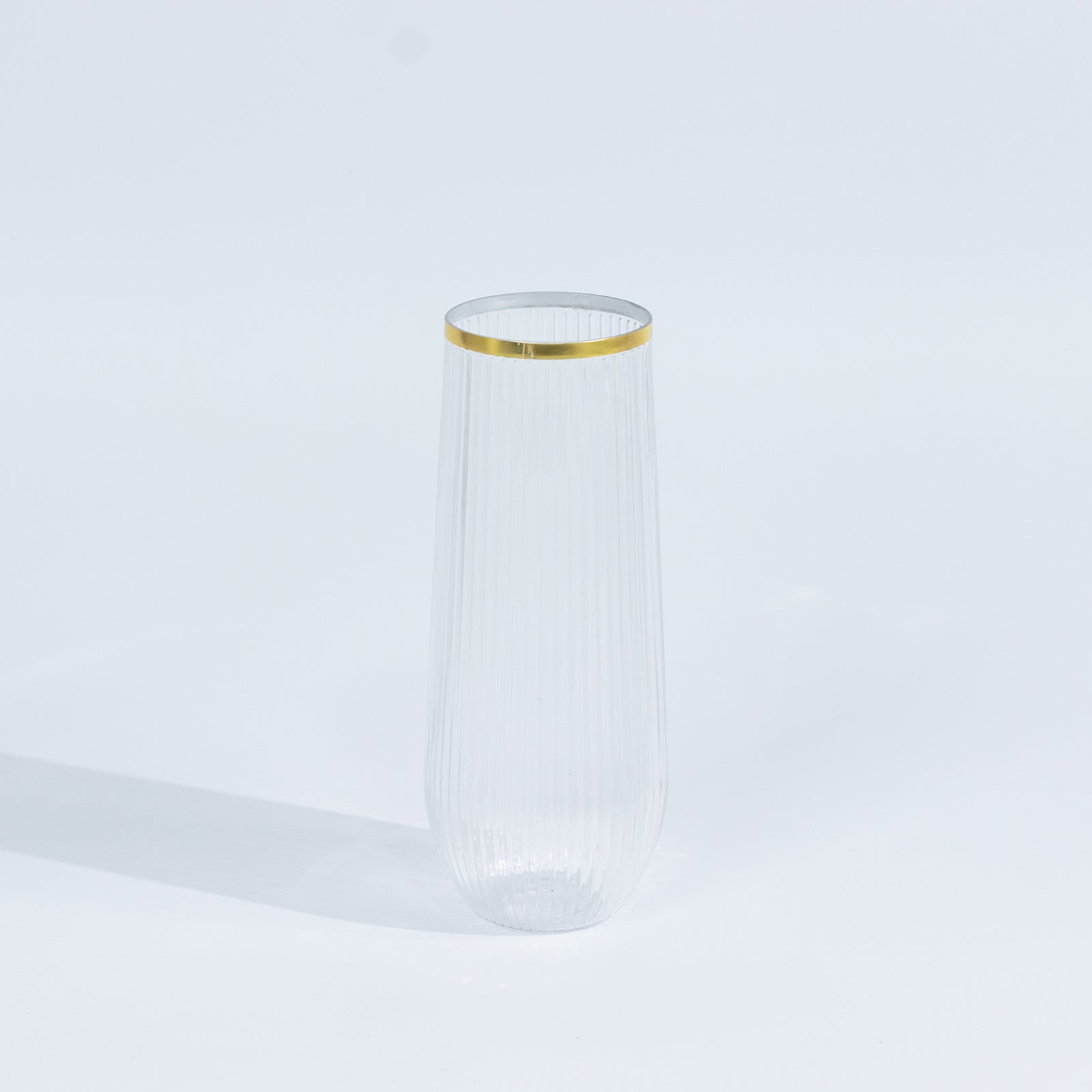 Clear stemless plastic champagne flute with gold rim.