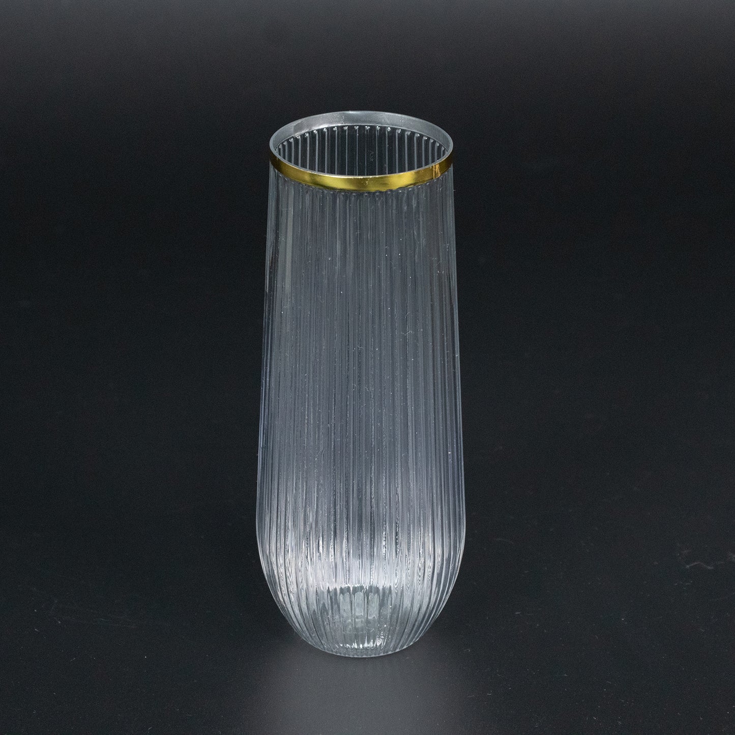 Clear ribbed plastic champagne flute with gold rim.