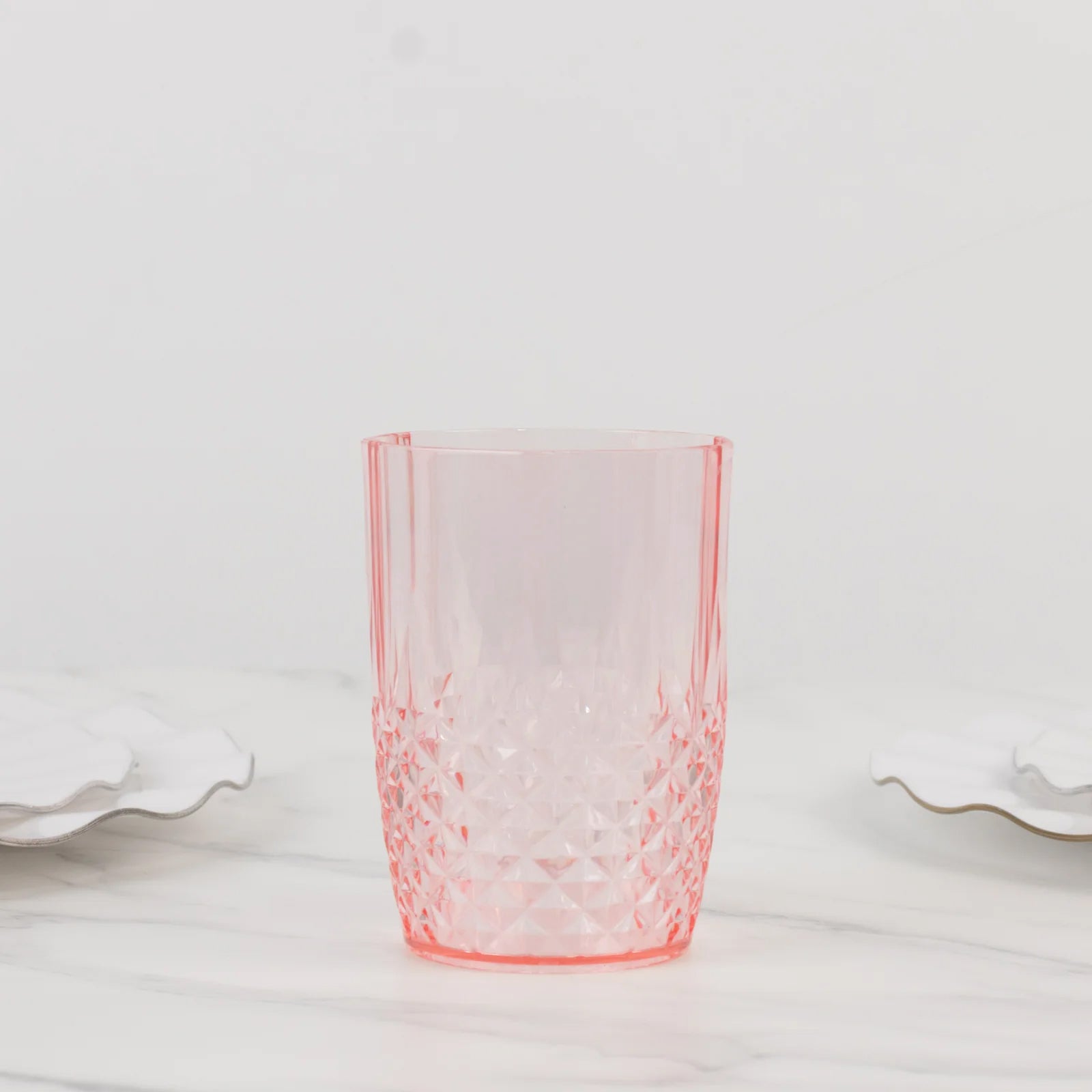 Transparent blush reusable plastic tumbler glass in crystal cut style.