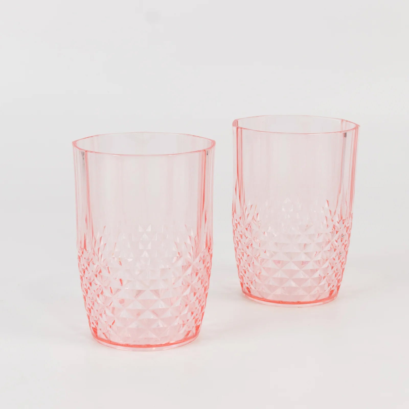 Transparent blush reusable plastic tumbler glasses in crystal cut style.