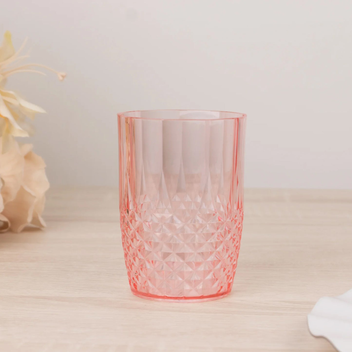 Transparent blush reusable plastic tumbler glass in crystal cut style.