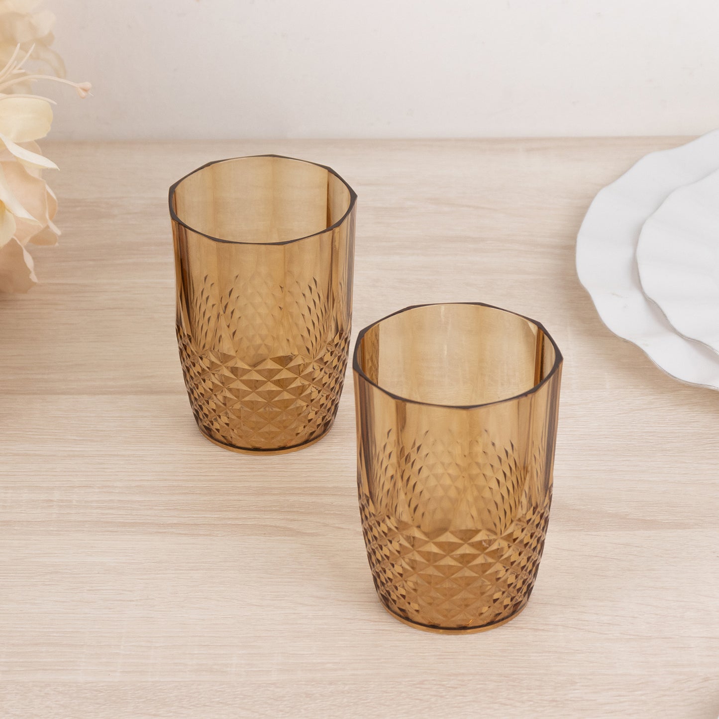 Amber gold reusable plastic tumbler glasses in crystal cut style.