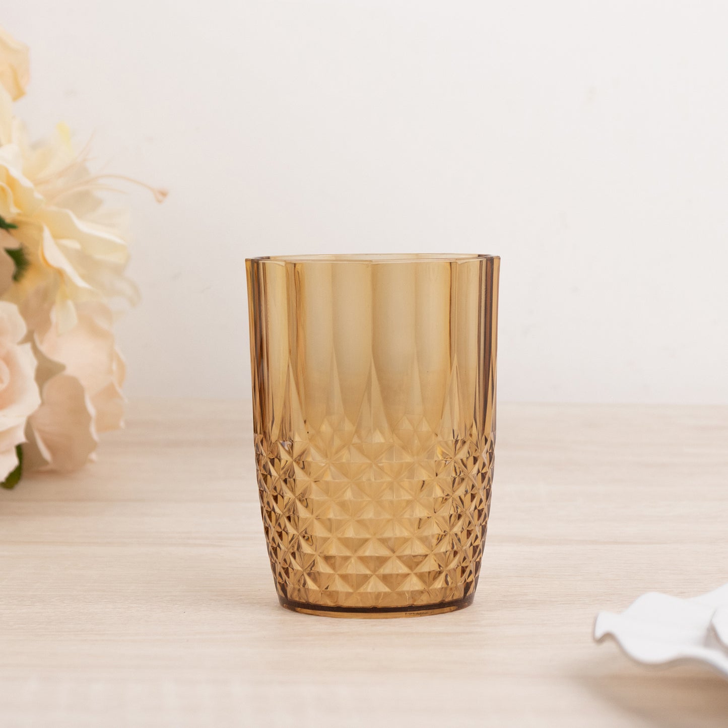 Amber gold reusable plastic tumbler glass in crystal cut style.