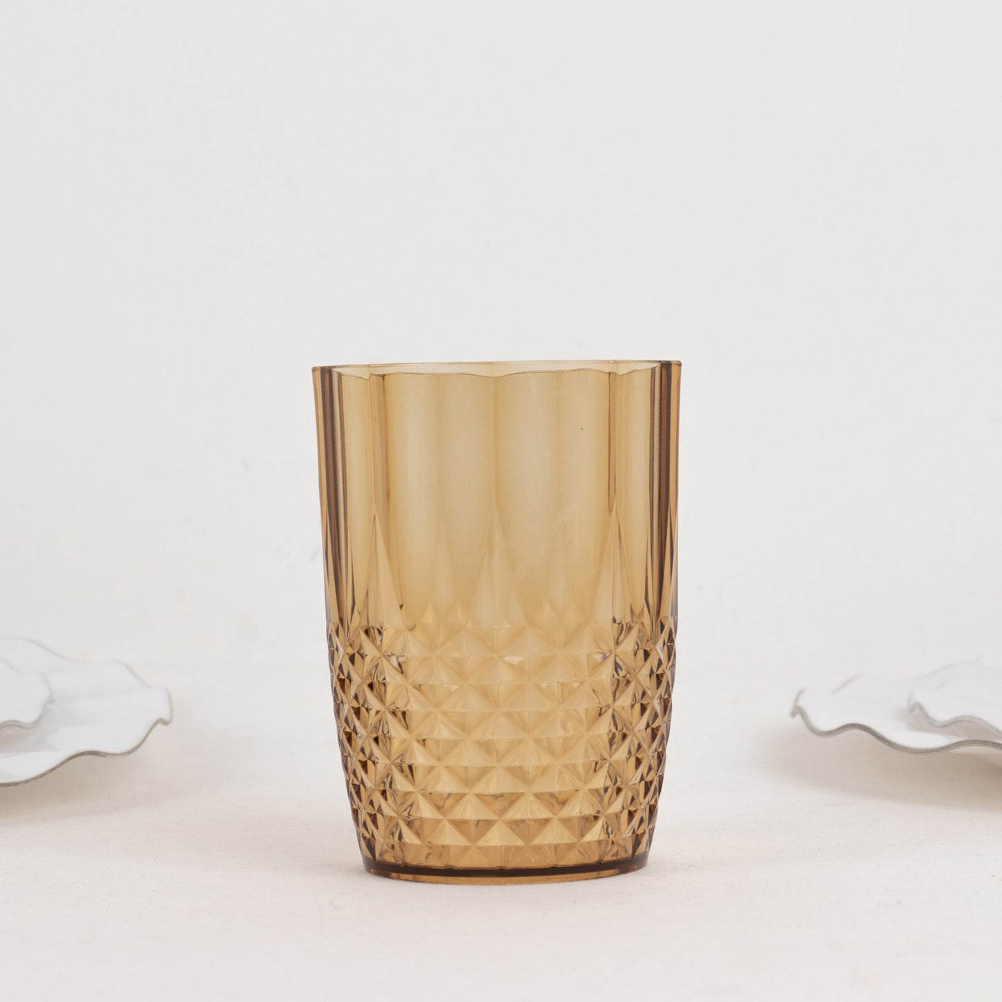 Amber gold reusable plastic tumbler glass in crystal cut style.