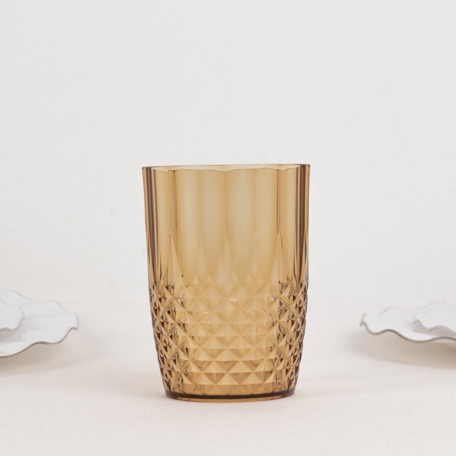 Amber gold reusable plastic tumbler glass in crystal cut style.