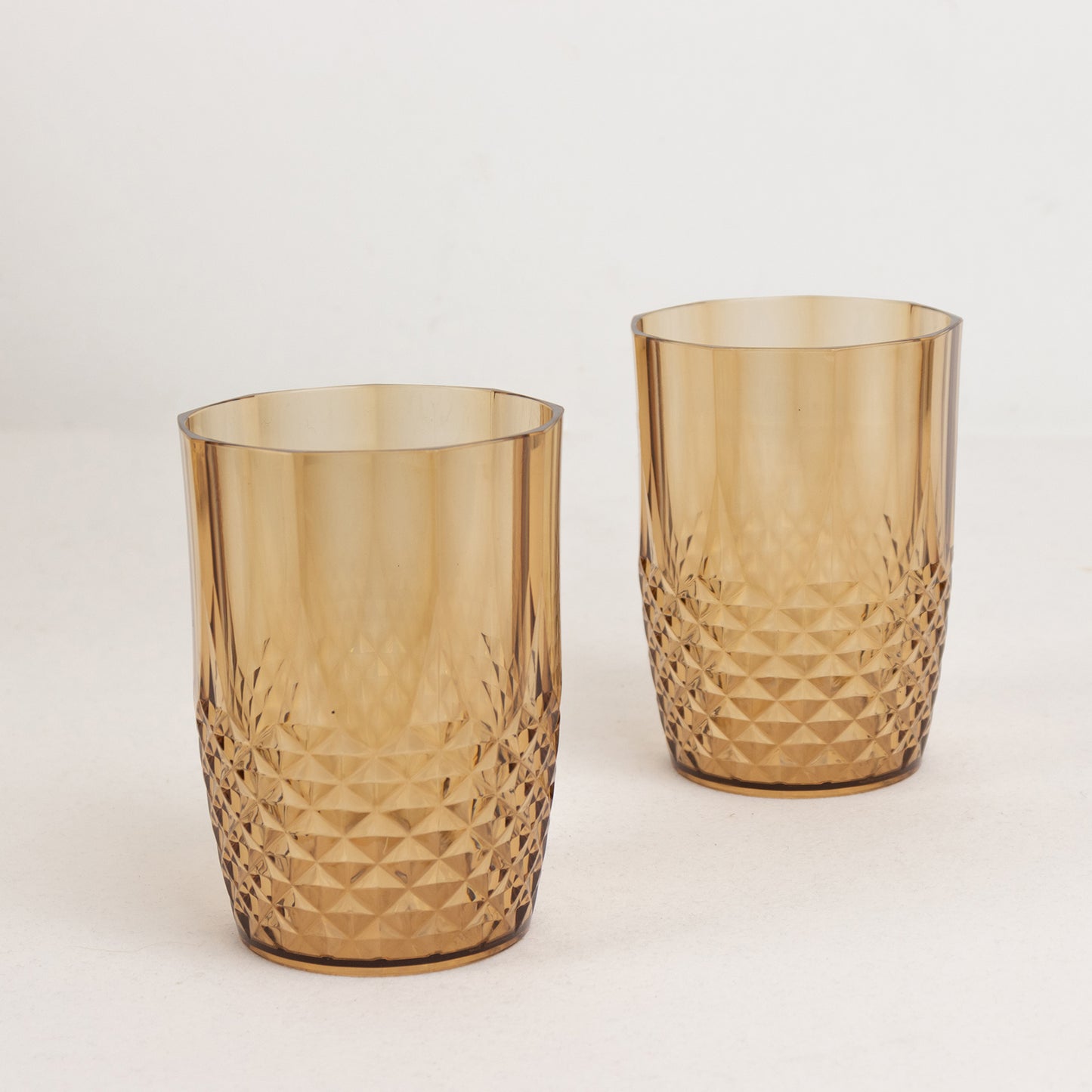 Amber gold reusable plastic tumbler glasses in crystal cut style.