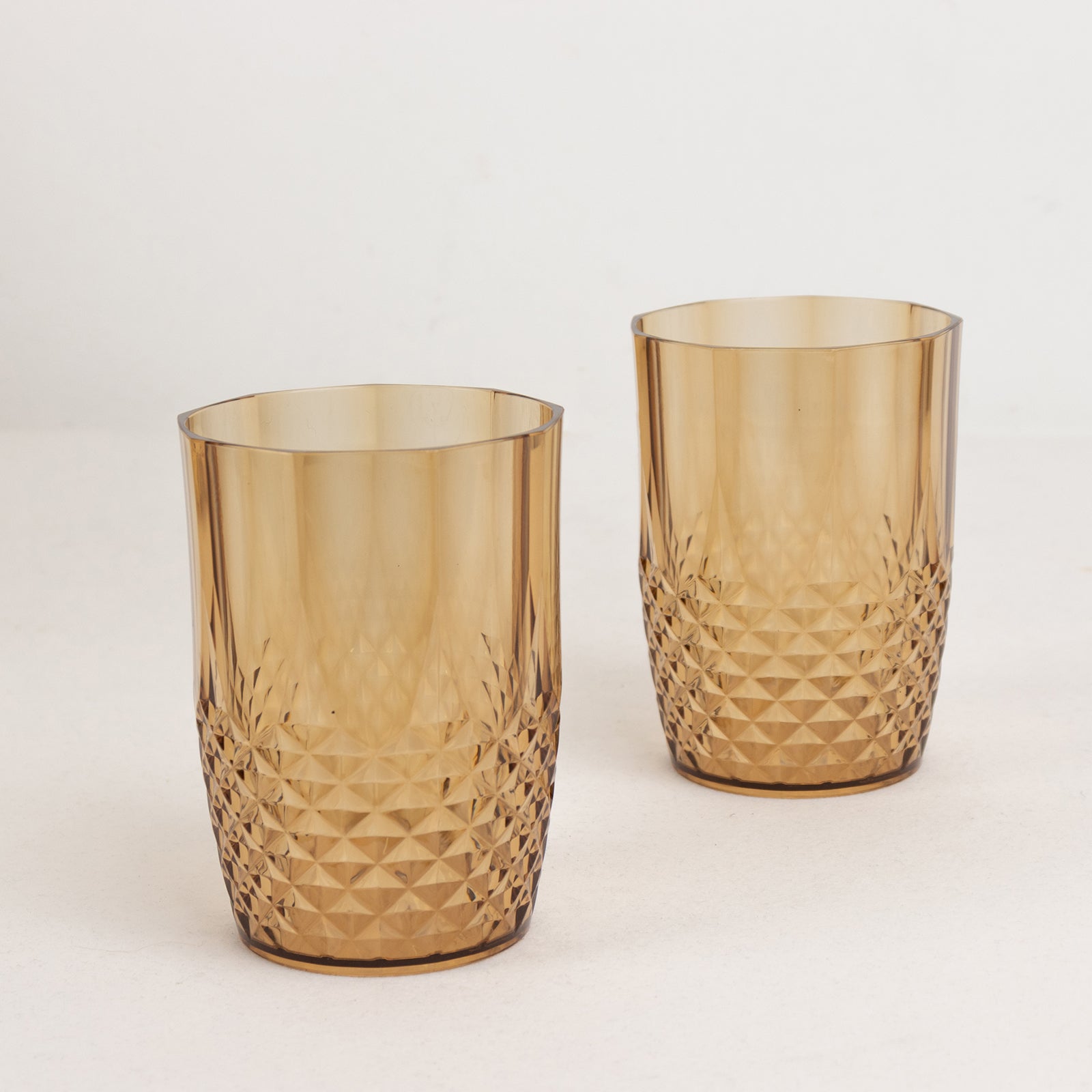 Amber gold reusable plastic tumbler glasses in crystal cut style.