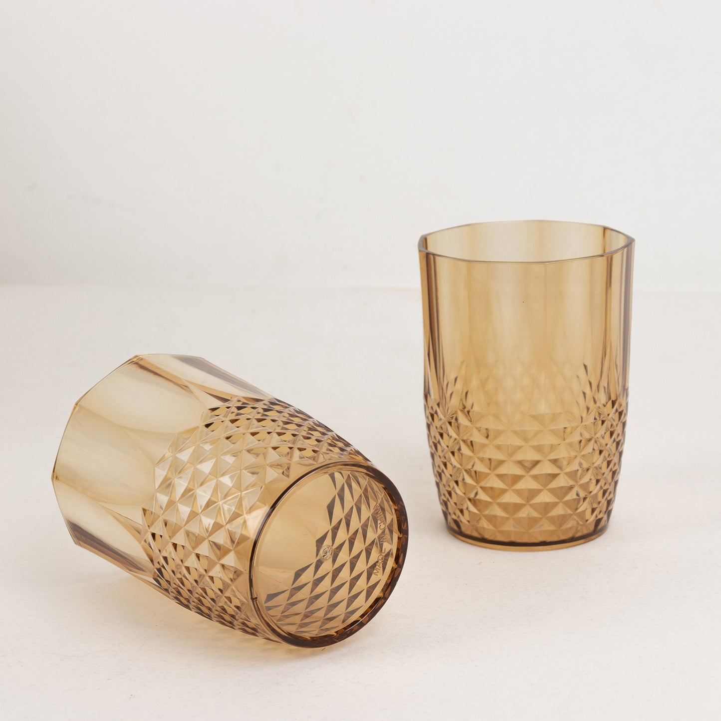 Amber gold reusable plastic tumblers in crystal cut style.