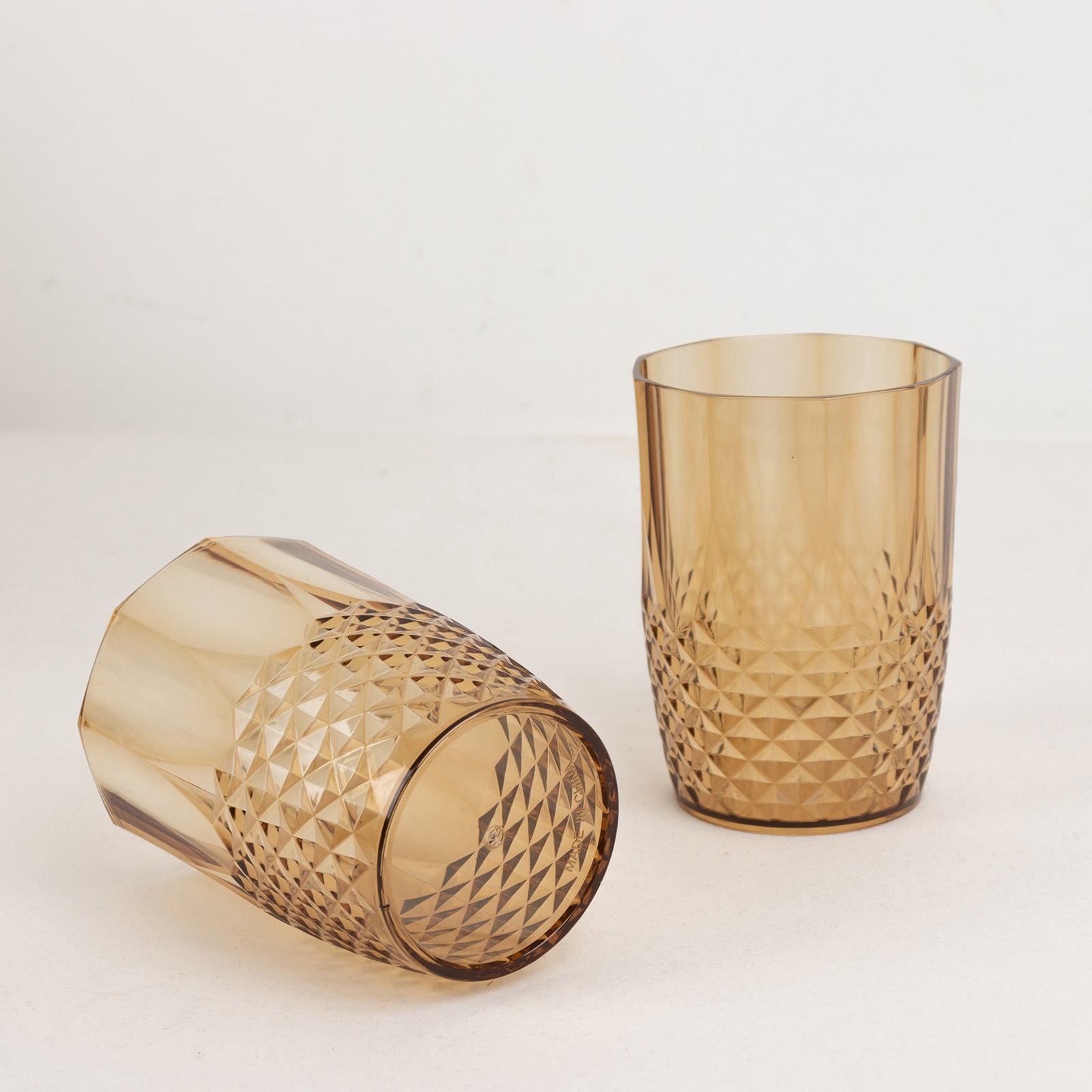 Amber gold reusable plastic tumblers in crystal cut style.