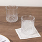 Clear crystal cut plastic stemless wine glasses on a wooden table.