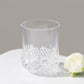 Clear crystal cut plastic stemless wine glass on a neutral background.