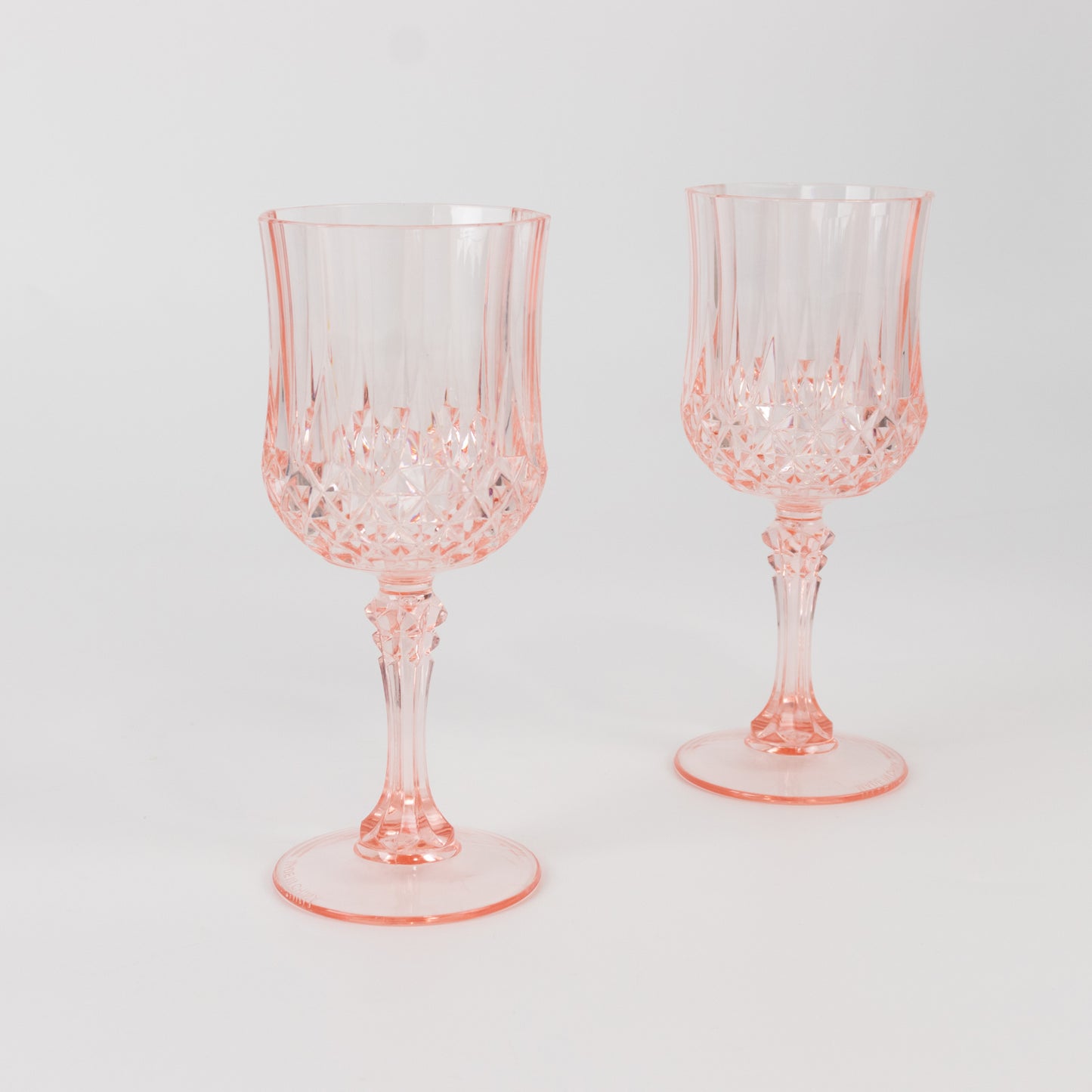Transparent blush crystal cut reusable plastic cocktail goblets.