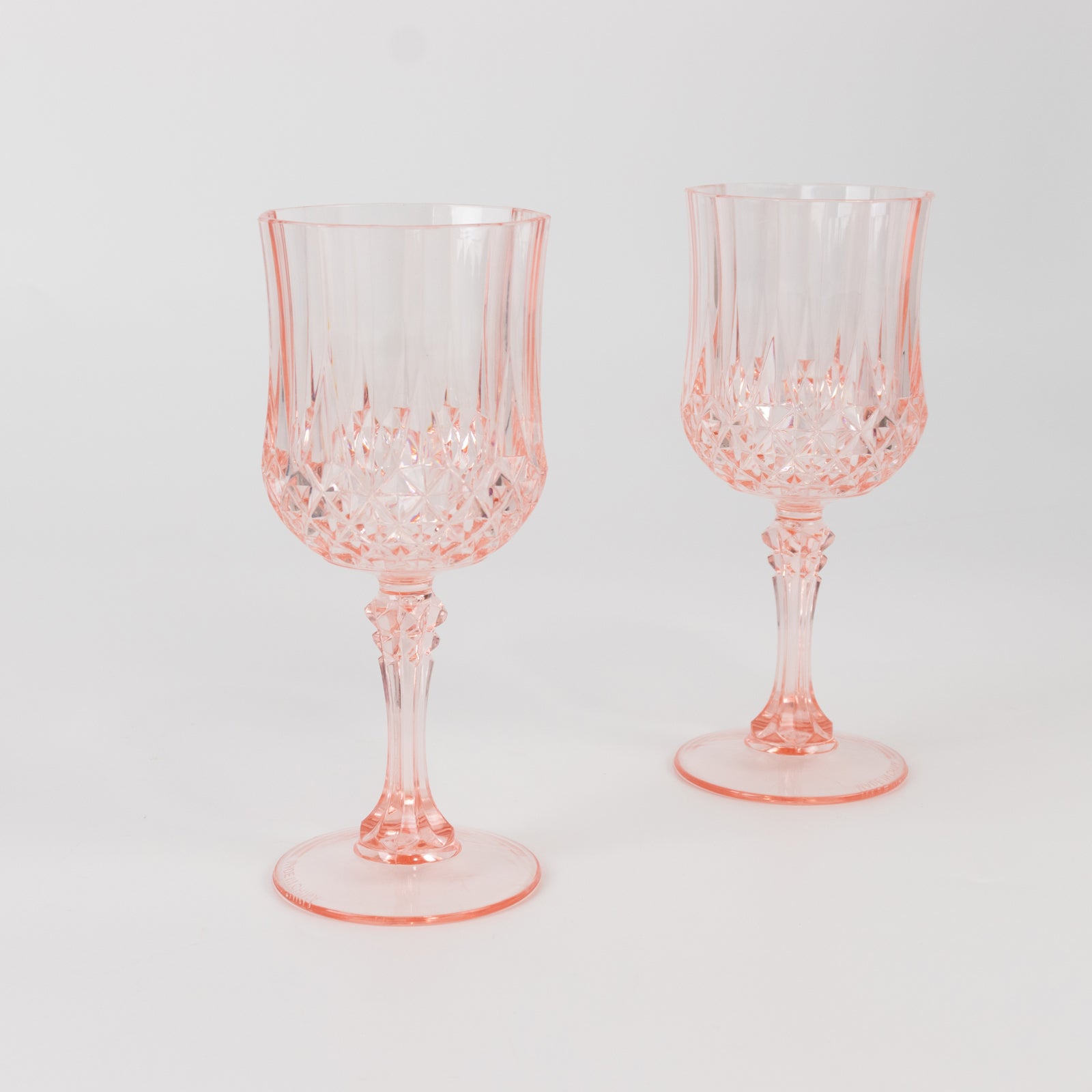 Transparent blush crystal cut reusable plastic cocktail goblets.