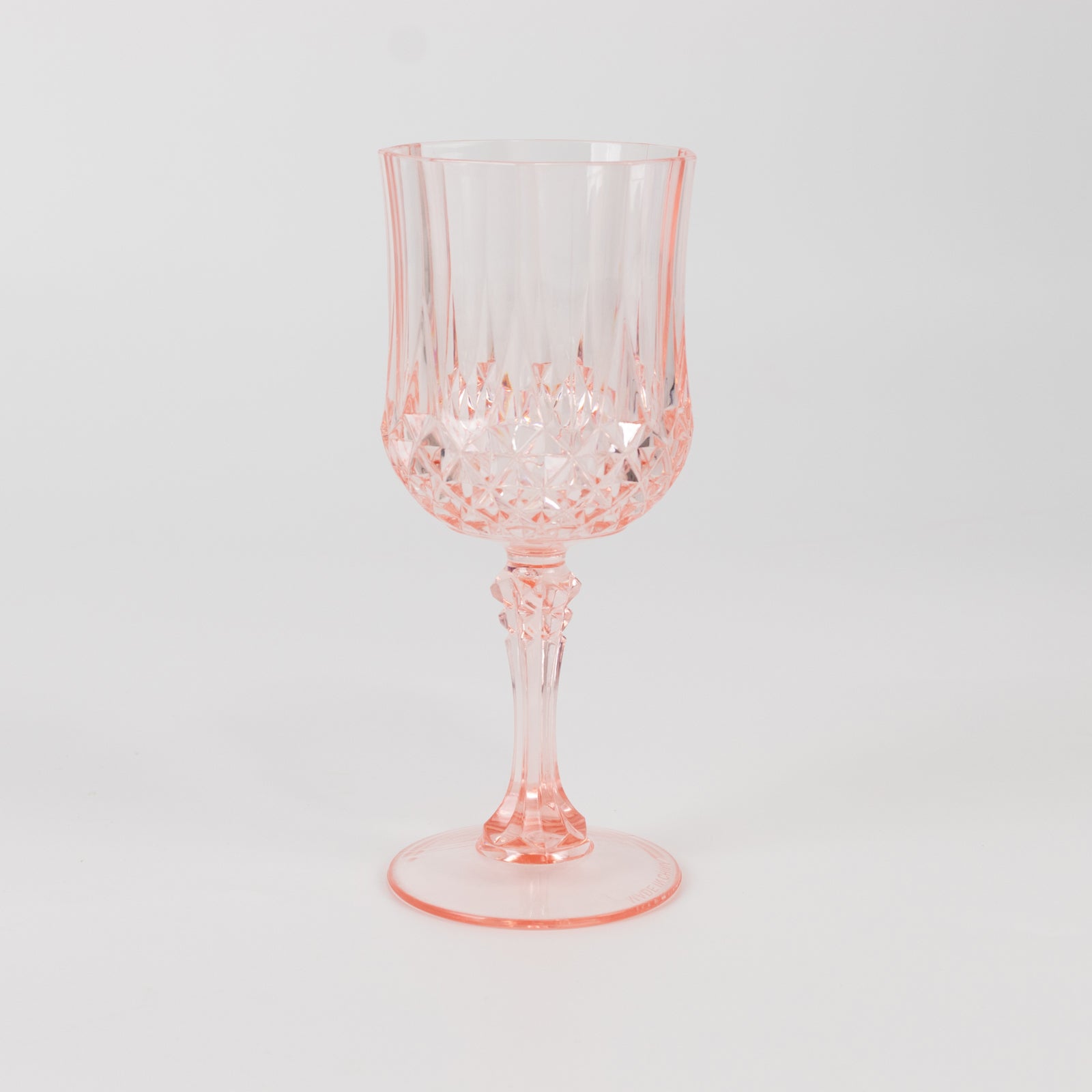 Transparent blush crystal cut reusable plastic cocktail goblet.