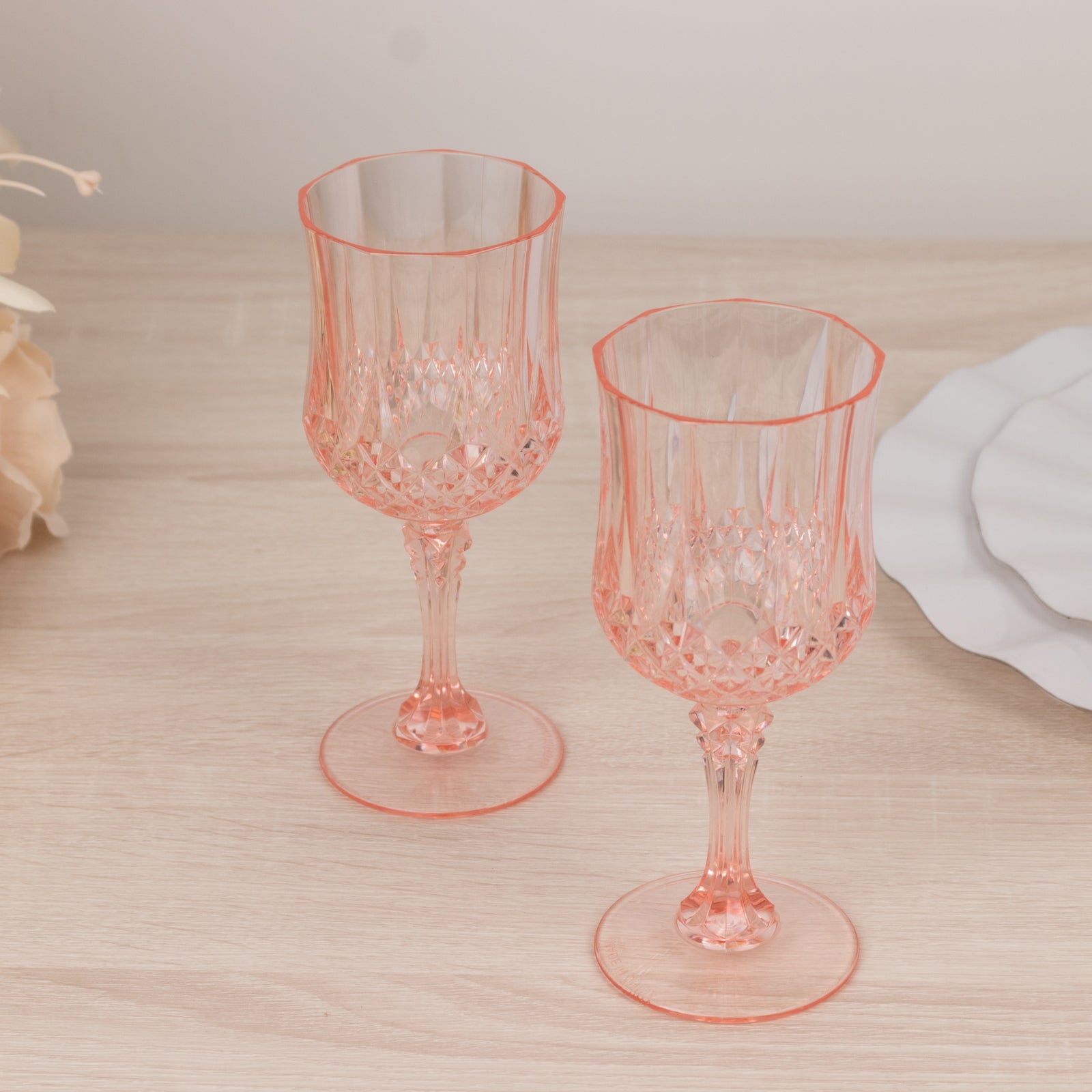 Transparent blush crystal cut reusable plastic cocktail goblets.