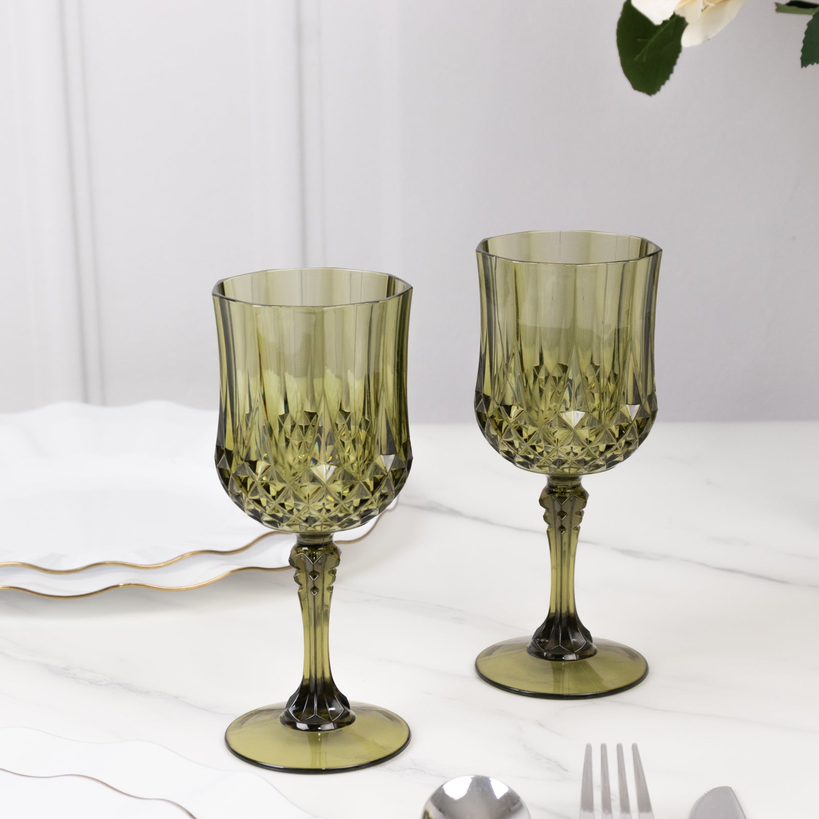 Dusty sage green shatterproof cocktail goblets on a table setting.
