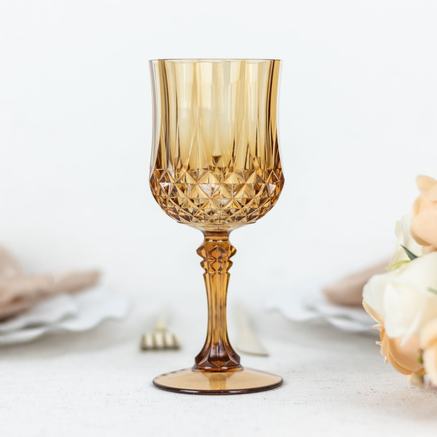 Amber gold crystal cut reusable plastic cocktail goblet.