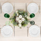 Assorted green crystal cut reusable plastic cocktail goblets on a dining table.